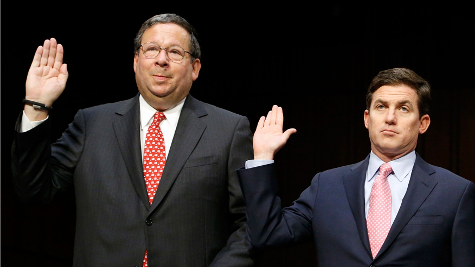 Comcast Executive Vice President David Cohen (L) and Time Warner Cable Inc. Executive Vice President and CFO Arthur Minson (R) are sworn in to testify before a Senate Judiciary Committee hearing on the Comcast-Time Warner Cable merger on Capitol Hill in Washington April 9, 2014. Executives from Comcast Corp and Time Warner Cable Inc are expected to defend their plan to merge as they go before the Senate Judiciary Committee on Wednesday, the first hearing since the $45.2-billion deal was announced in February.