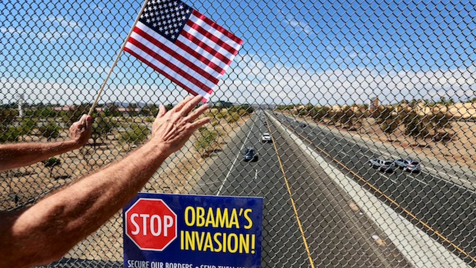 An anti-immigration protester holds a flag and waves to motorists on a highway overpass on Murrieta Hot Springs Blvd in Murrieta, California July 19, 2014. U.S. President Barack Obama will meet with the leaders of Honduras, Guatemala and El Salvador next week to discuss cooperation on the influx of child migrants from Central America into the United States, senior administration officials said on Friday. REUTERS/Sandy Huffaker (UNITED STATES - Tags: SOCIETY IMMIGRATION CIVIL UNREST POLITICS) - RTR3ZD18