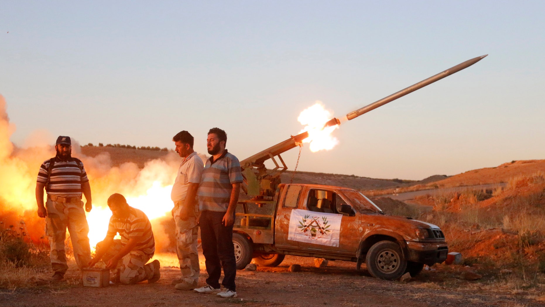 July 25, 2014 - Free Syrian Army fighters launch a rocket towards Hama military airport that is controlled by forces loyal to Syria's President Bashar al-Assad, in the Hama countryside.