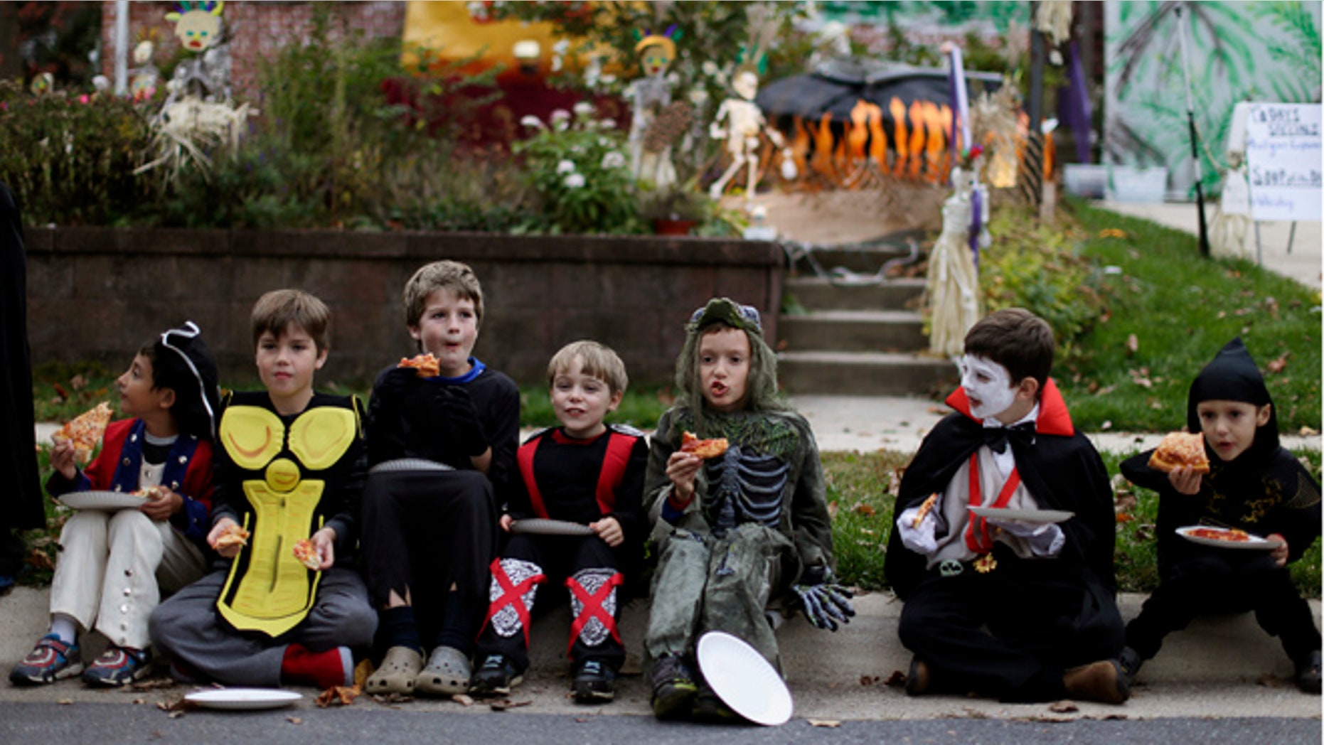 Oct. 31, 2014: Children dressed in costumes eat pizza on Halloween.