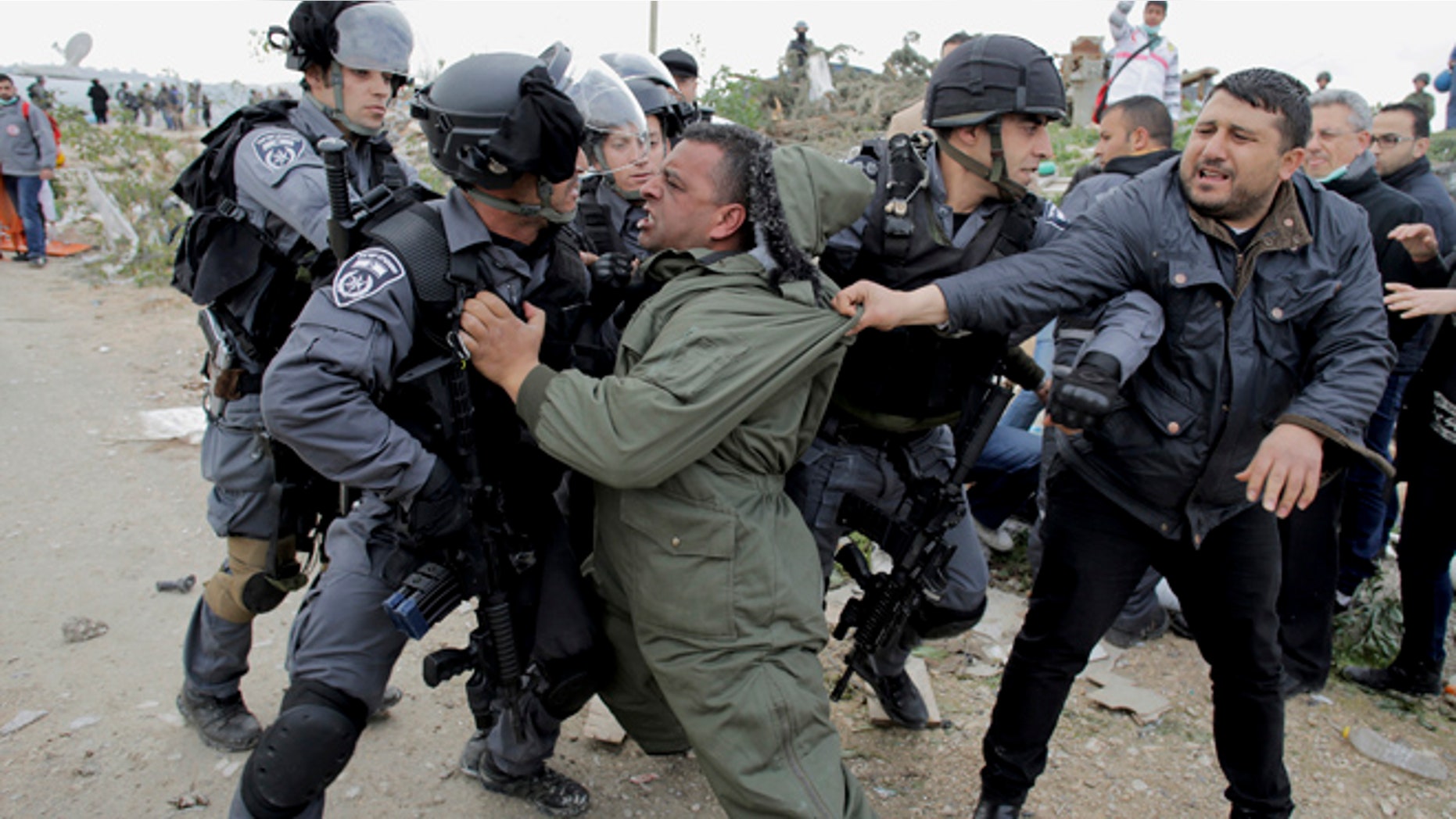 Feb. 16, 2015: A Palestinian man scuffles with Israeli border policemen as they clear a protest on land that Palestinians said was confiscated by Israel for Jewish settlements.