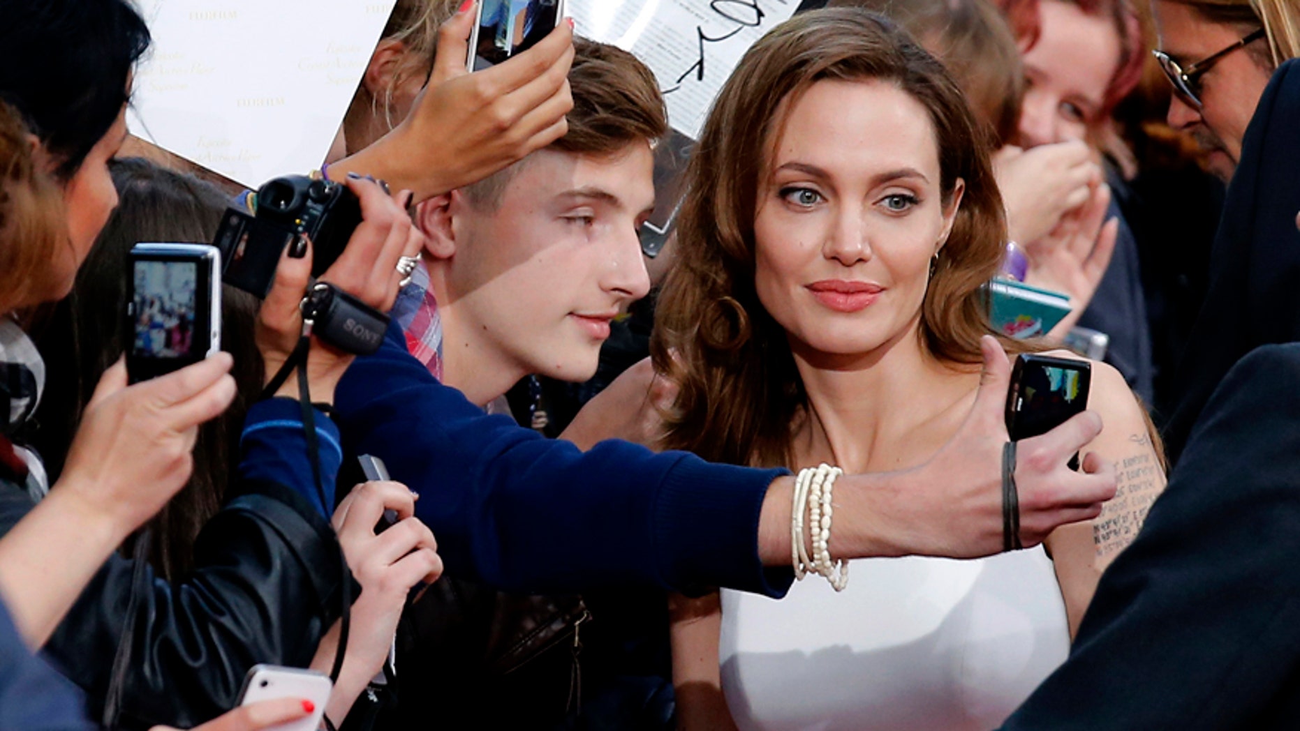 Angelina Jolie (C) poses for a selfie with a fan during the premiere of the film World War Z in Berlin June 4, 2013.
