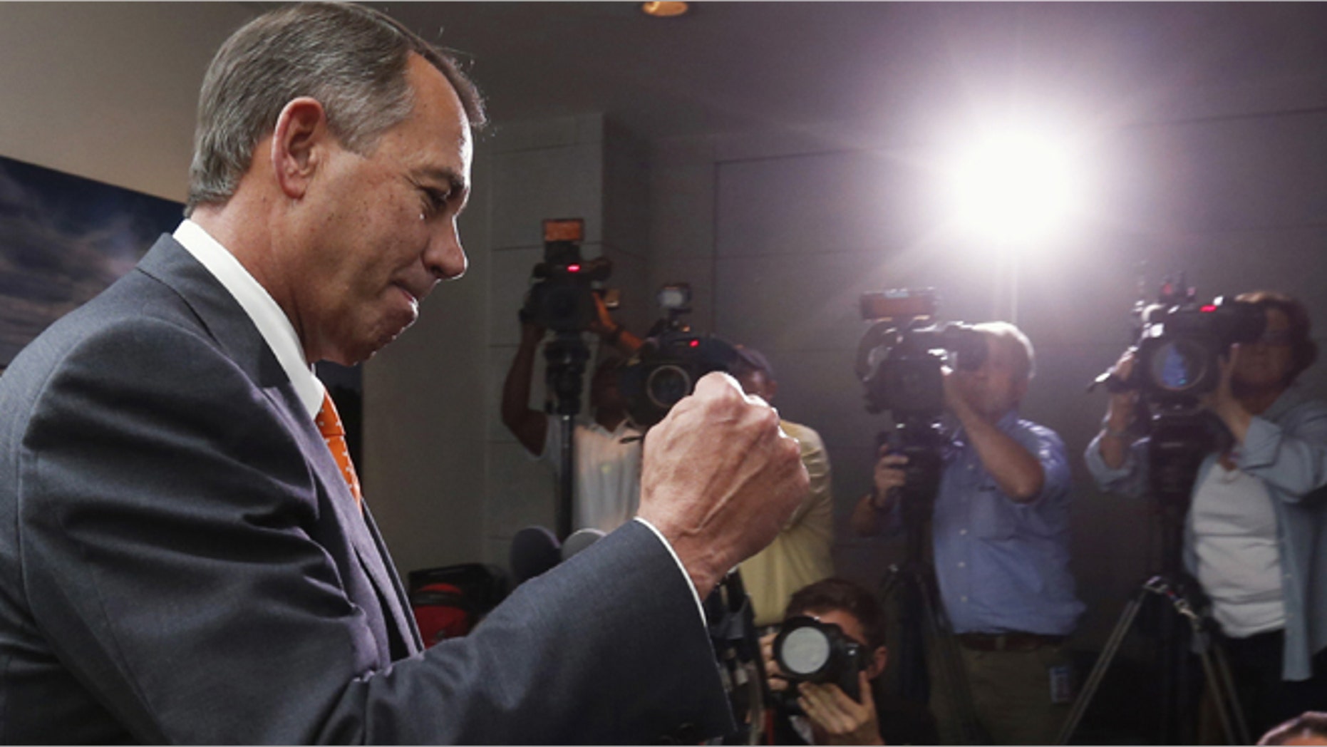 Speaker of the House John Boehner pumps his fist as he emerges from a meeting with Republican House members in the U.S. Capitol in Washington October 16, 2013.