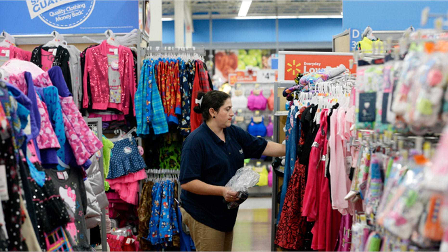 A worker stocks merchandise at the Wal-Mart Superstore in the Porter Ranch section of Los Angeles November 26, 2013.