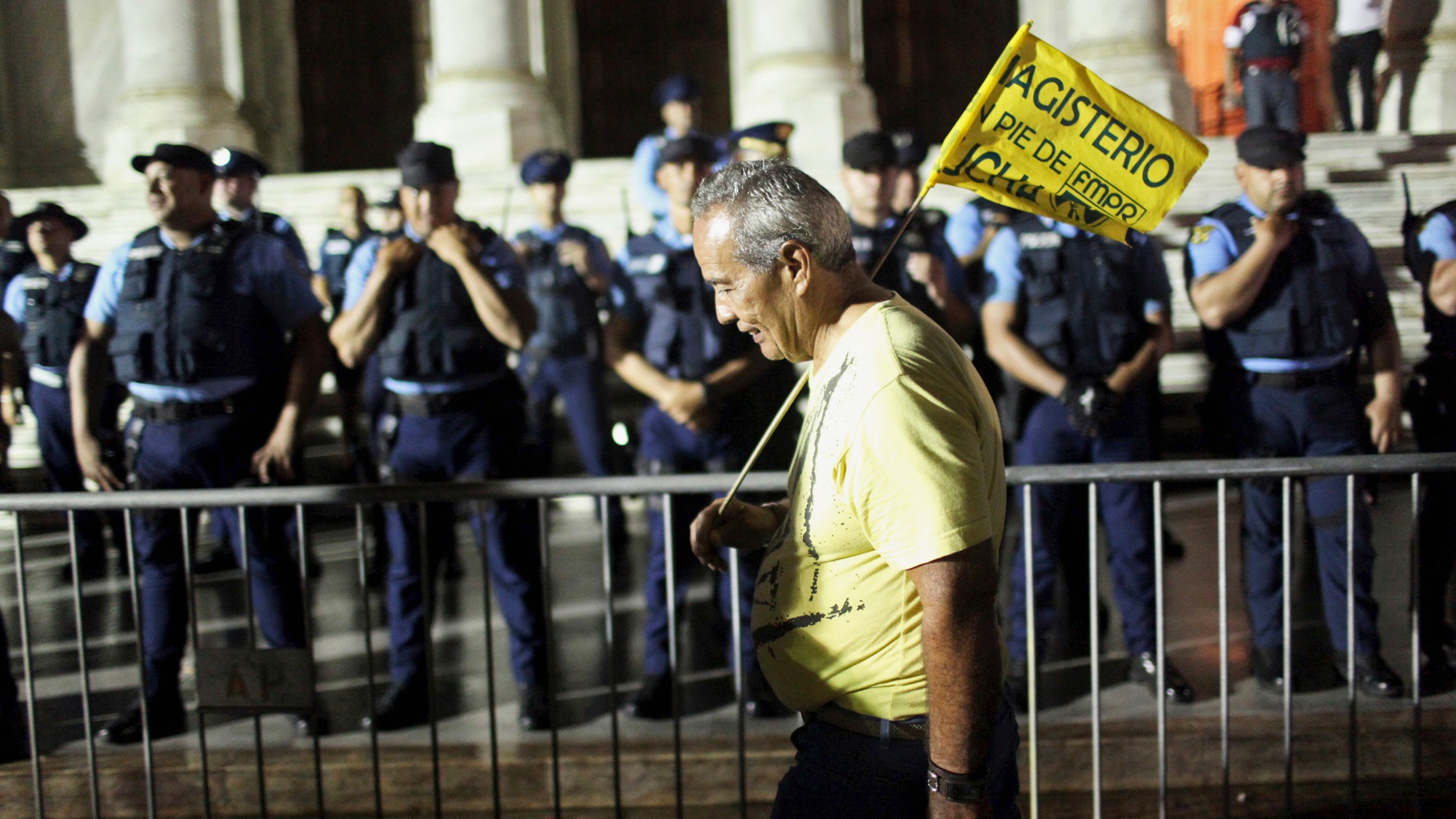 A schoolteacher demonstrates outside of the Capitol building as the Lower House of Congress voted to approve modifications to the Teacher's Pension System in San Juan, December 21, 2013. Puerto Rico, with an economy in or near recession for the last eight years, has chronic budget shortfalls and has spawned worry among investors in the $3.7 trillion municipal debt market, where its bond prices have plunged this year. Picture taken December 21, 2013. REUTERS/Alvin Baez (PUERTO RICO - Tags: EDUCATION POLITICS BUSINESS EMPLOYMENT) - RTX16RDT