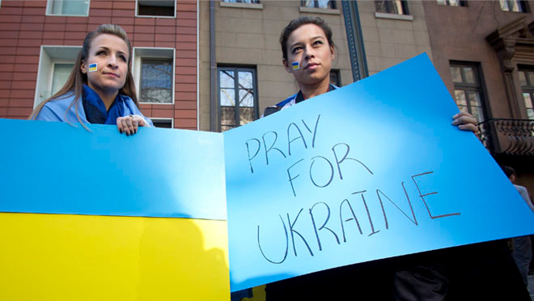 Feb. 23, 2014: A woman carries a Ukraine flag and another a sign of support in New York City.