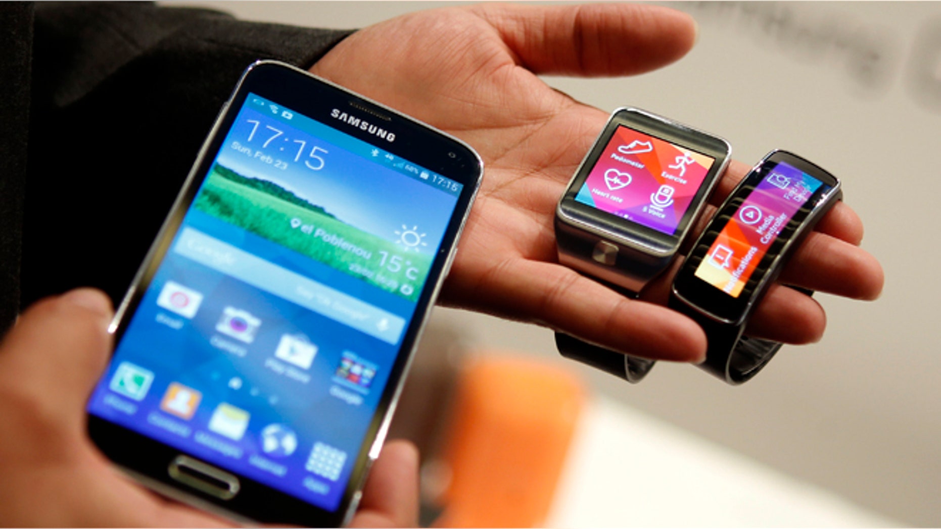 New Samsung Galaxy S5 smartphone (L), Gear 2 smartwatch (C) and Gear Fit fitness band are displayed at the Mobile World Congress in Barcelona.