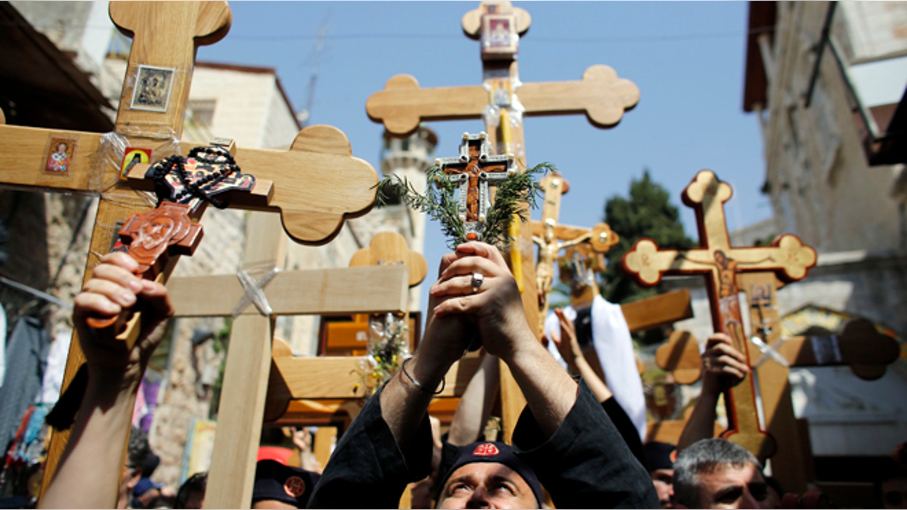 Orthodox Christian worshippers hold crosses as they take part in the Eastern and Orthodox Church's Good Friday procession along the Via Dolorosa in Jerusalem's Old City.