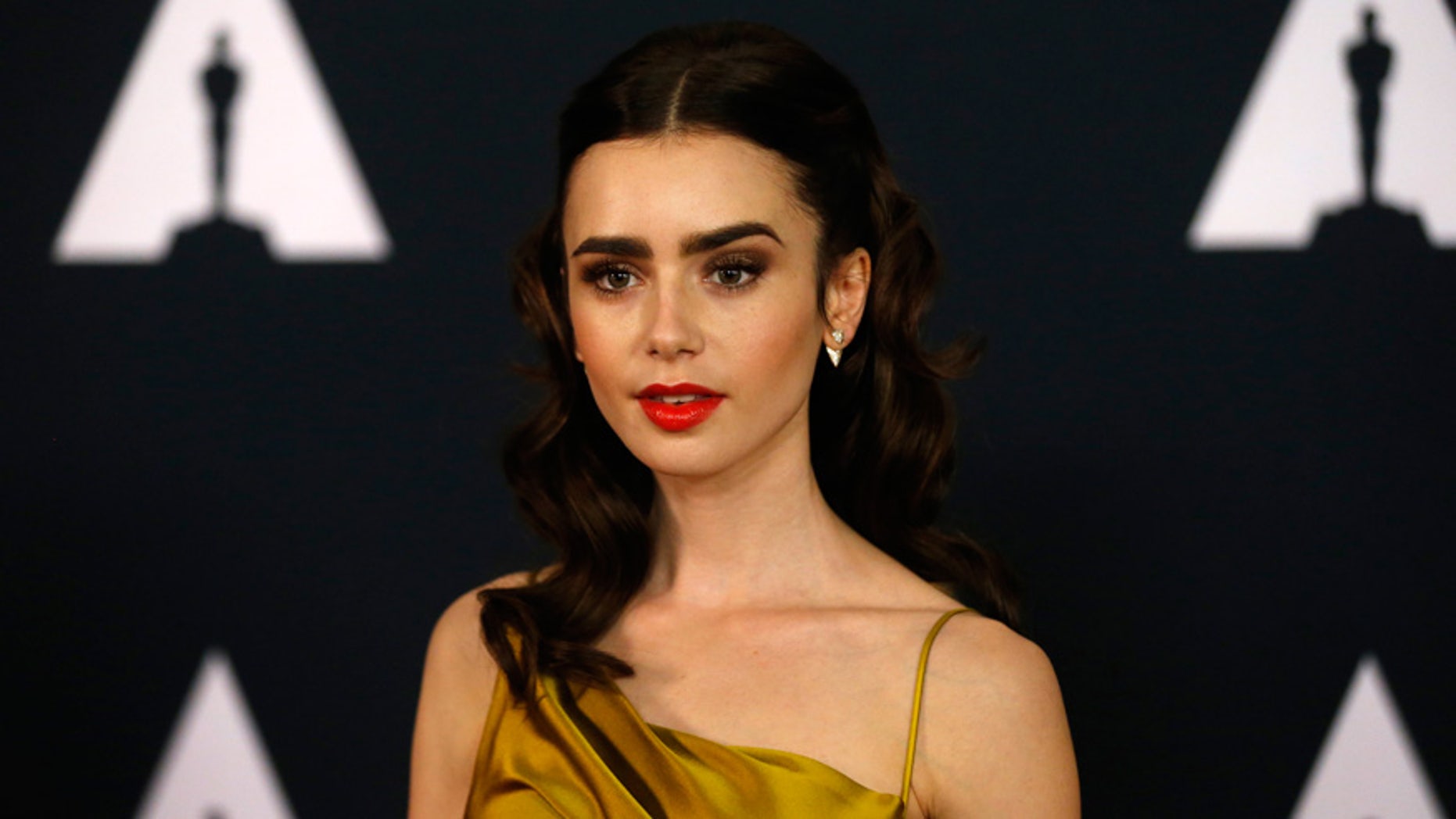 Lily Collins poses at an event.