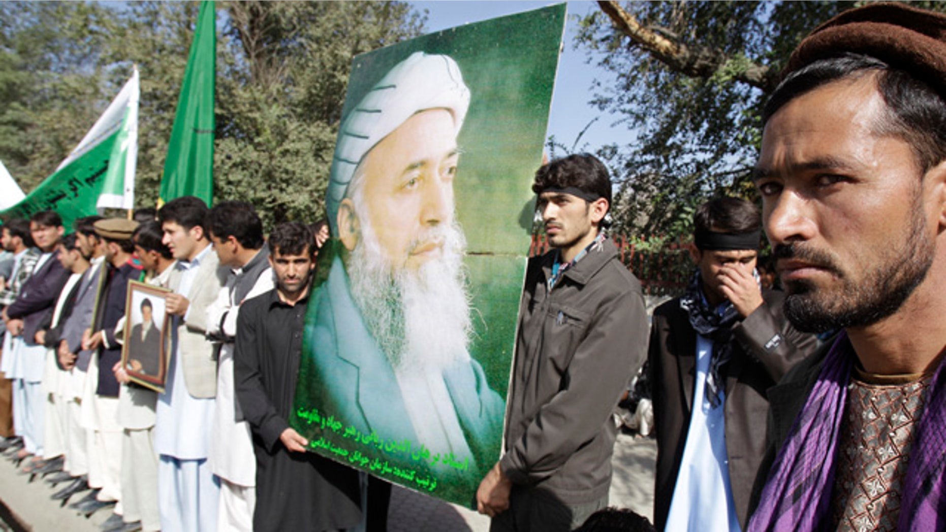 Sept. 21: A man holds a poster of former Afghan President Burhanuddin Rabbani during a rally in Kabul, after he was killed by a blast the previous day.