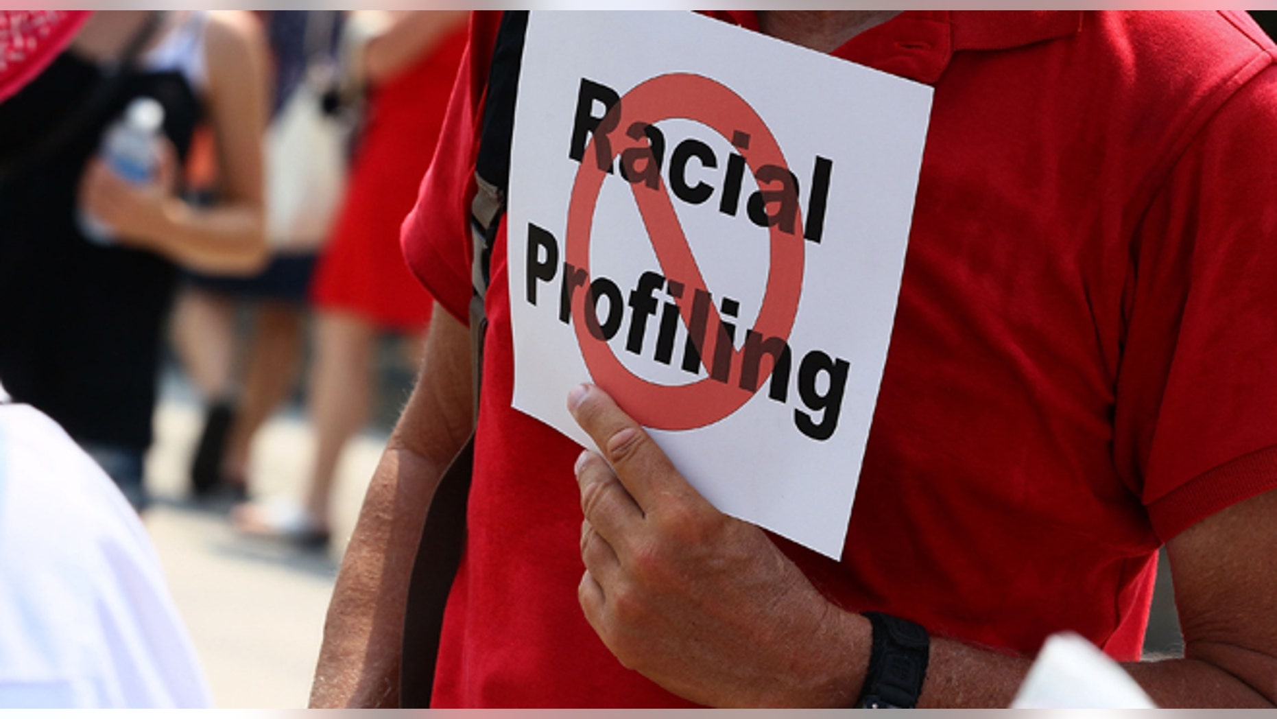 WASHINGTON - JULY 07: A man holds a sign against racial profiling during a protest with Community and faith leaders from Arizona in front of the White House on July 7, 2010 in Washington, DC. Activists plan a 24-hour vigil outside the White House to protest the imminent new immigration law in Arizona. (Photo by Mark Wilson/Getty Images)