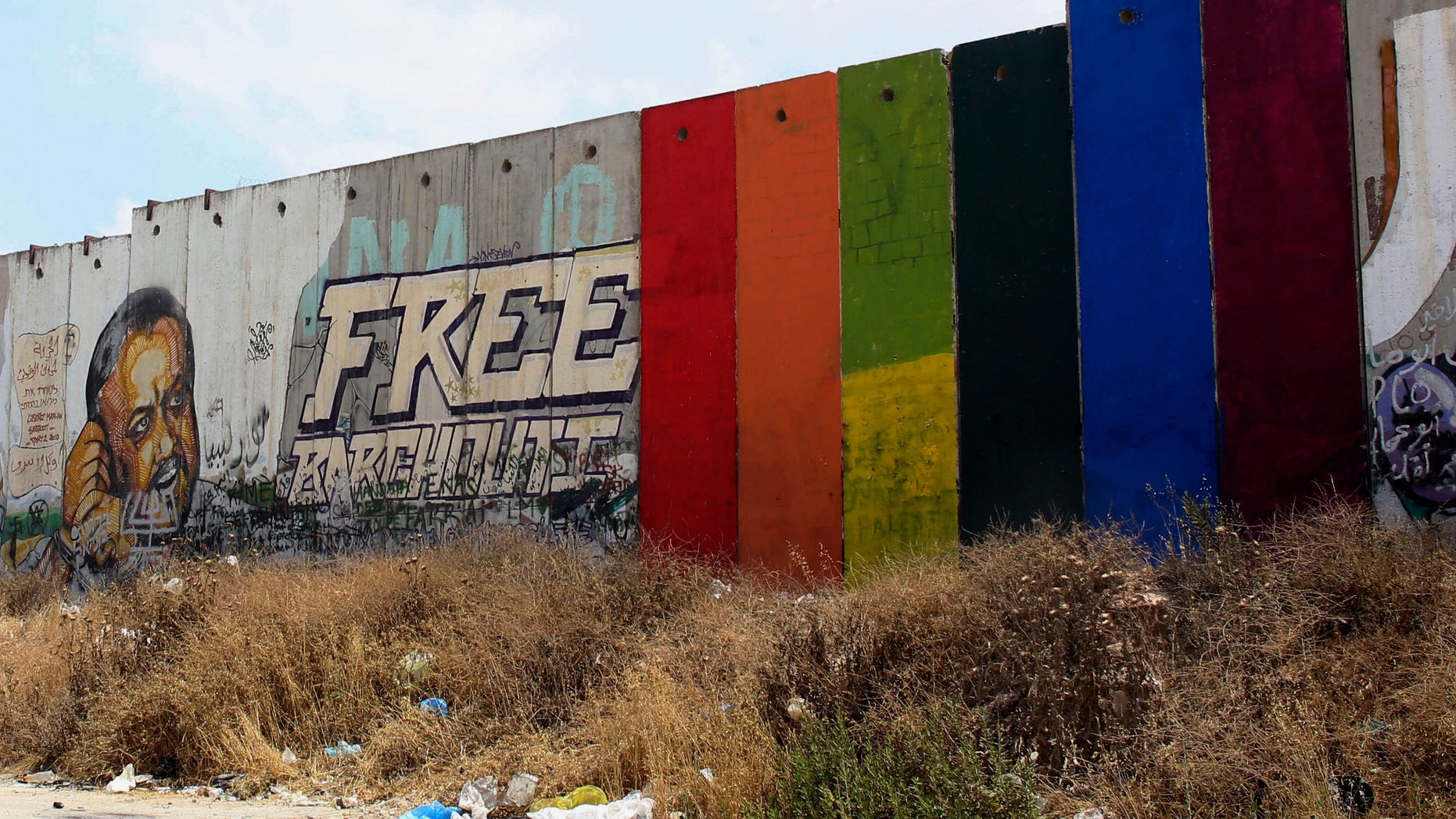 Monday, June 29, 2015: Palestinian artist Khaled Jarrar shows his painting of a rainbow flag on six slabs of the West Bank separation barrier in the West Bank city of Ramallah.