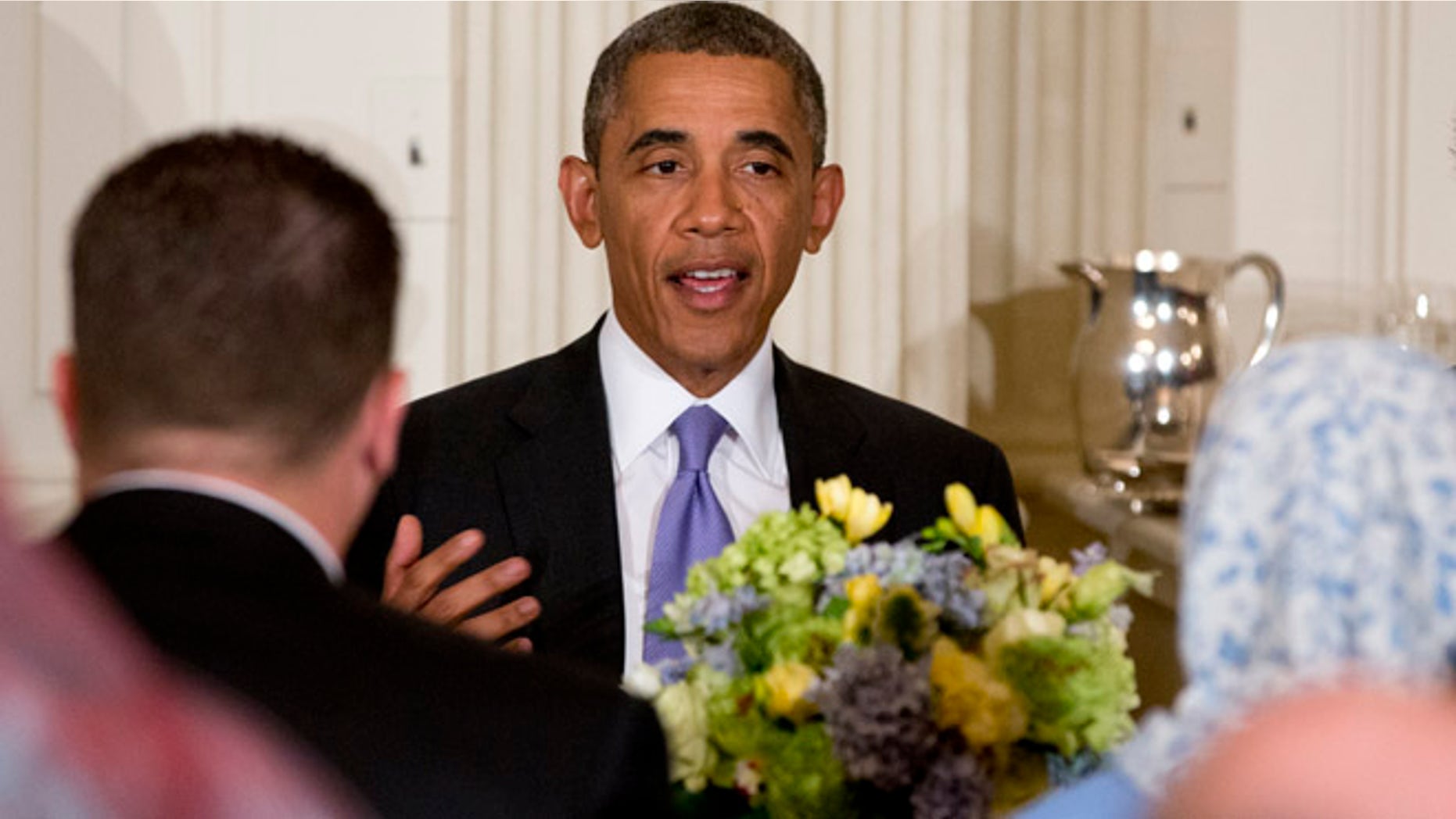 July 25, 2013: President Barack Obama talks as he sits a a table during an Iftar dinner celebrating Ramadan in the State Dining Room of the White House, Thursday, July 25, 2013, in Washington.