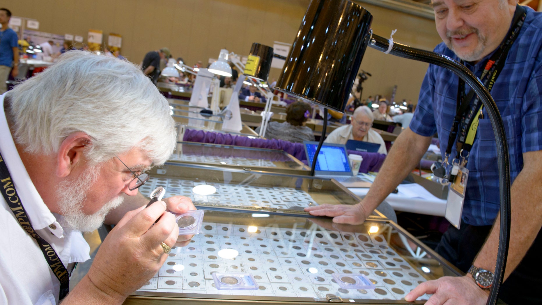May 9, 2013: John Edgar, left, of Knoxville, Tenn., looks at "must have" rare coins at the booth of Eugene Bruder of Chico, Calif., during the National Money Show held by the American Numismatic Association in the New Orleans Convention Center in New Orleans.
