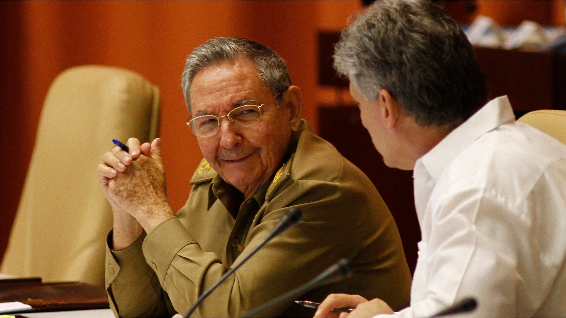 Cuba's President Raul Castro, left, and Vice President Miguel Diaz-Canel talk during the second day of a twice-annual legislative sessions, at the National Assembly in Havana, Cuba, Sunday, July 7, 2013. Observers will be watching to see if the new vice president is taking on increasing responsibility since assuming the post in what was seen as the beginning of a generational leadership transition. (AP Photo/Ismael Francisco, Cubadebate)