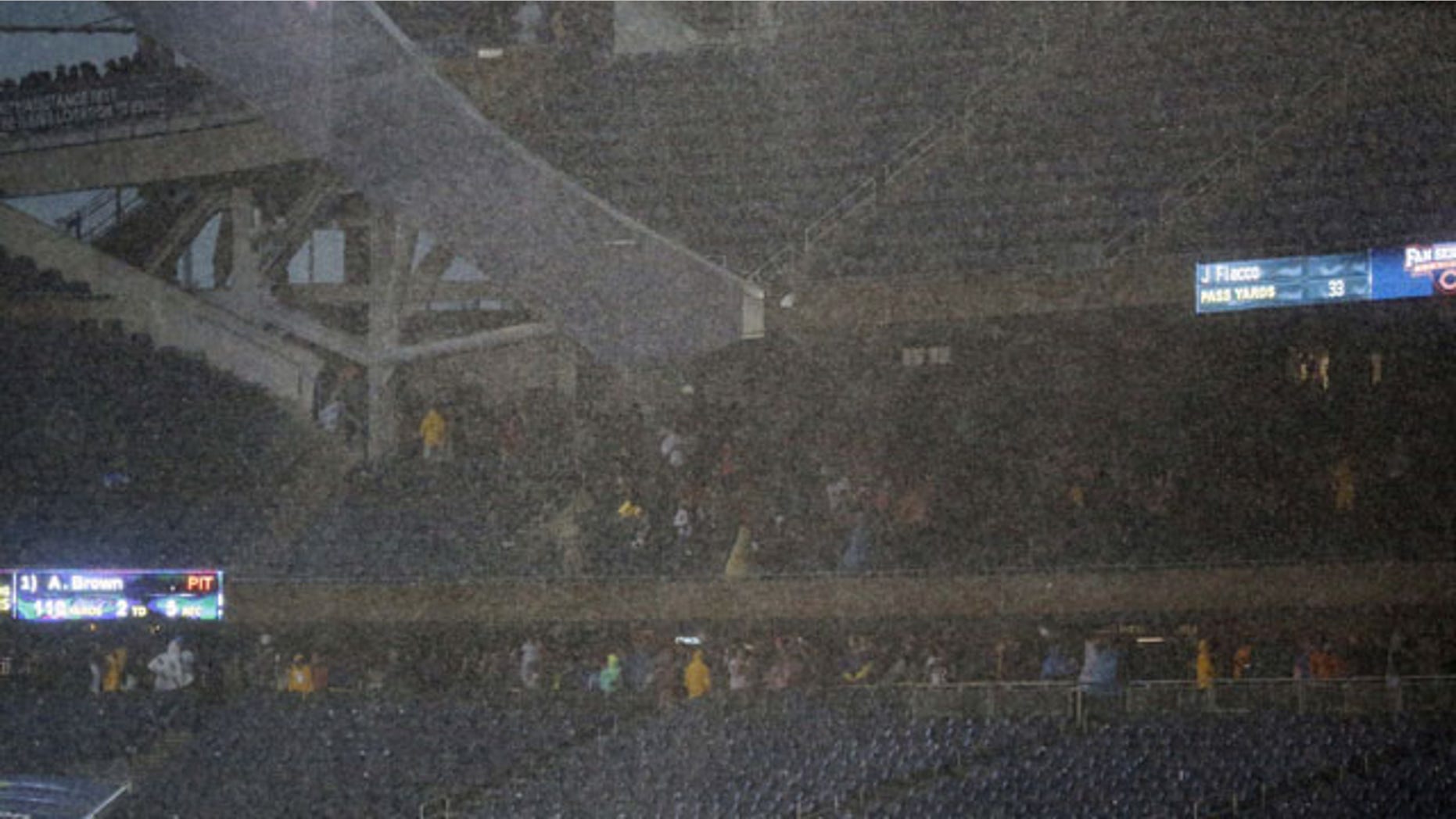 November 17, 2013: Fan seek shelter under the stands as a severe storm blows over Soldier Field in Chicago during the first half of an NFL football game between the Chicago Bears and Baltimore Ravens. (AP Photo)