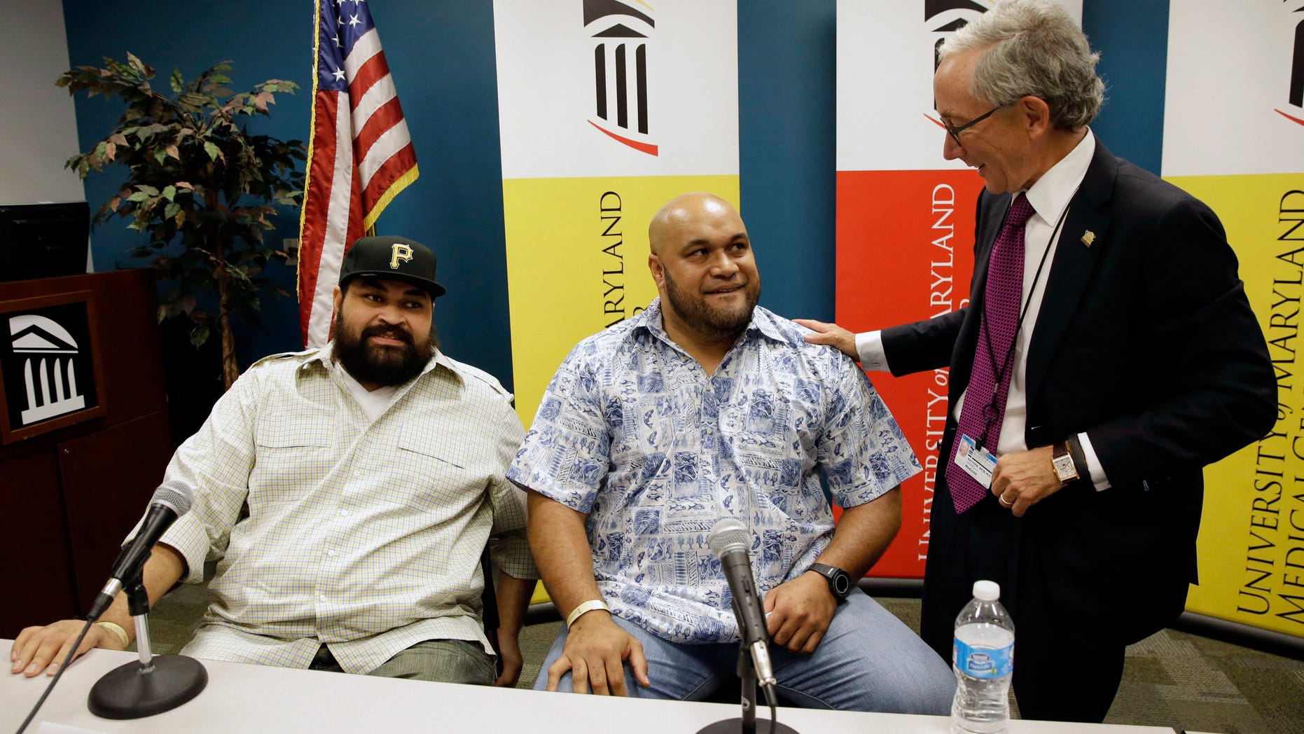 Sept. 17, 2014: Chris Kemoeatu, left, and his brother Ma'ake chat with Dr. Matthew Weir after a news conference at the University of Maryland Medical Center in Baltimore.