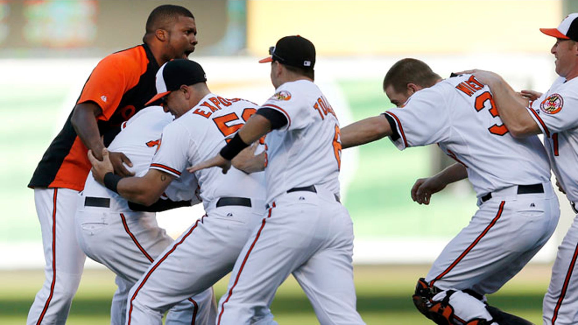Members of the Baltimore Orioles celebrate with Manny Machado, second from left, after Adam Jones scored a run on Machado's single in the 14th inning of a baseball game in Baltimore, Thursday, Sept. 13, 2012. Baltimore won 3-2. (AP Photo/Patrick Semansky)