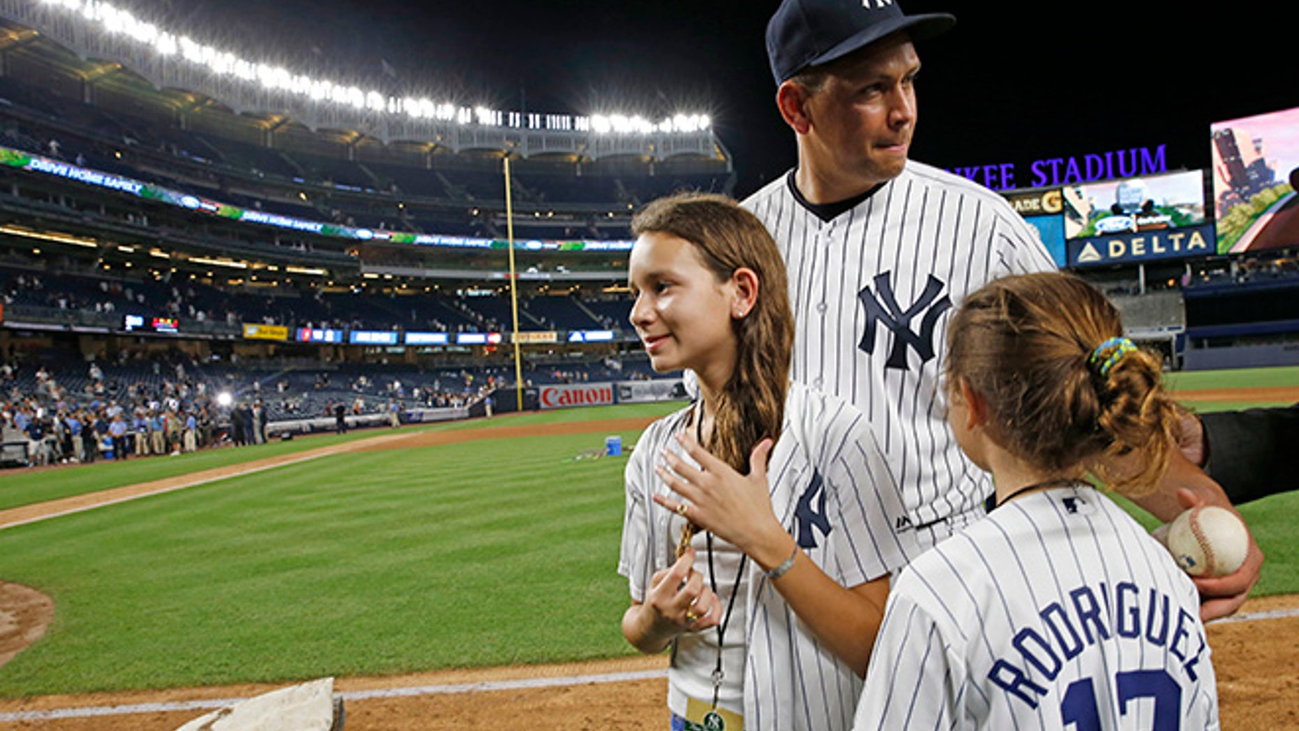 New York Yankees designated hitter Alex Rodriguez (13) gathers his daughters, Natasha, left, and Ella, before leaving the field after his final baseball game as a Yankee player, against the Tampa Bay Rays at Yankee Stadium in New York, Friday, Aug. 12, 2016. The Yankees won 6-3. (AP Photo/Kathy Willens)