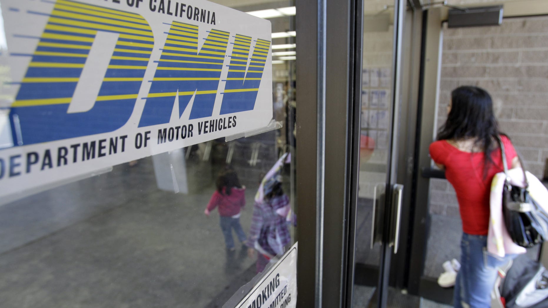 FILE - In this June 30, 2011 file photo, a customer walks into a Department of Motor Vehicles office in Redwood City, Calif. The U.S. Department of Homeland Security has granted a last-minute extension giving the state of California more time to comply with a federal Real ID Act, which sets stricter standards on identification. The state Department of Motor Vehicles announced Wednesday, Dec. 30, 2015, that the federal agency would have until Oct. 10, 2016 to comply with the rules. (AP Photo/Paul Sakuma, File)