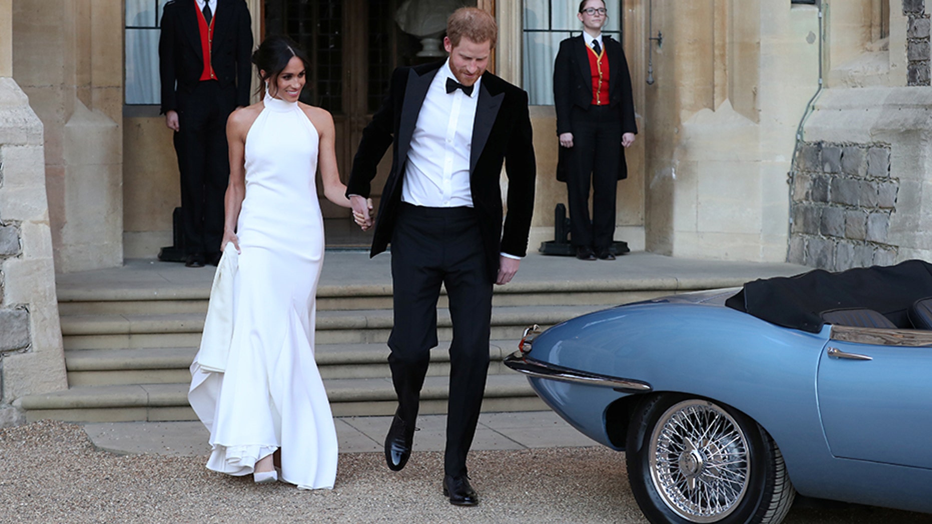 The newly married duke and duchess of Sussex, Meghan Markle and Prince Harry, prepare to leave Windsor Castle in a convertible car after their wedding in Windsor, England, to attend an evening reception at Frogmore House, hosted by the Prince of Wales, Saturday, May 19, 2018.