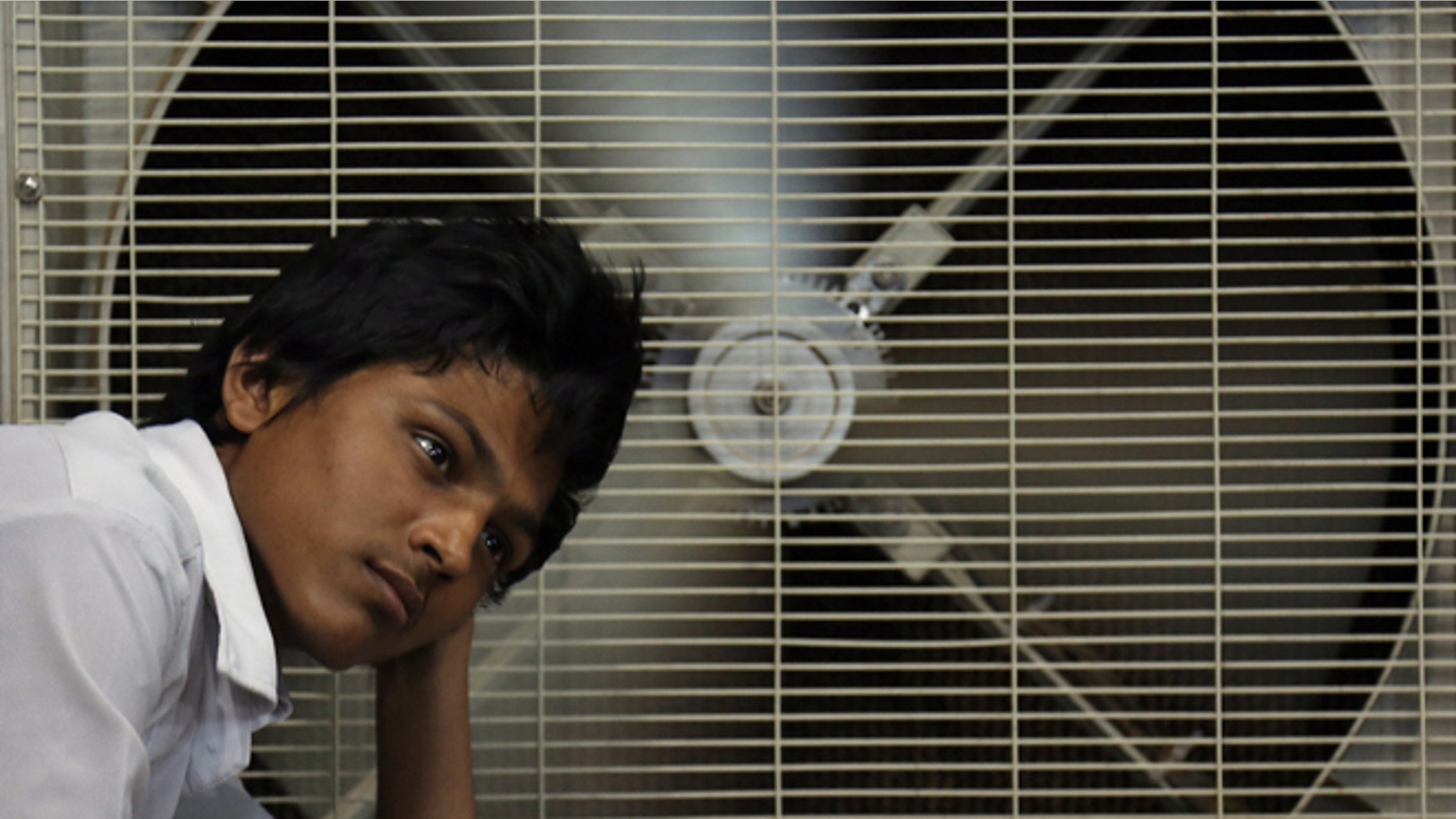 FILE - In this May 31, 2015 file photo, an Indian man rests in front of an air cooler to cool himself on a hot summer day in Hyderabad, in the southern Indian state of Telangana. Because of man-made global warming and a strong El Nino, Earths wild weather this year is bursting the annual heat record, the World Meteorological Organization announced Wednesday. (AP Photo/Mahesh Kumar A., File)