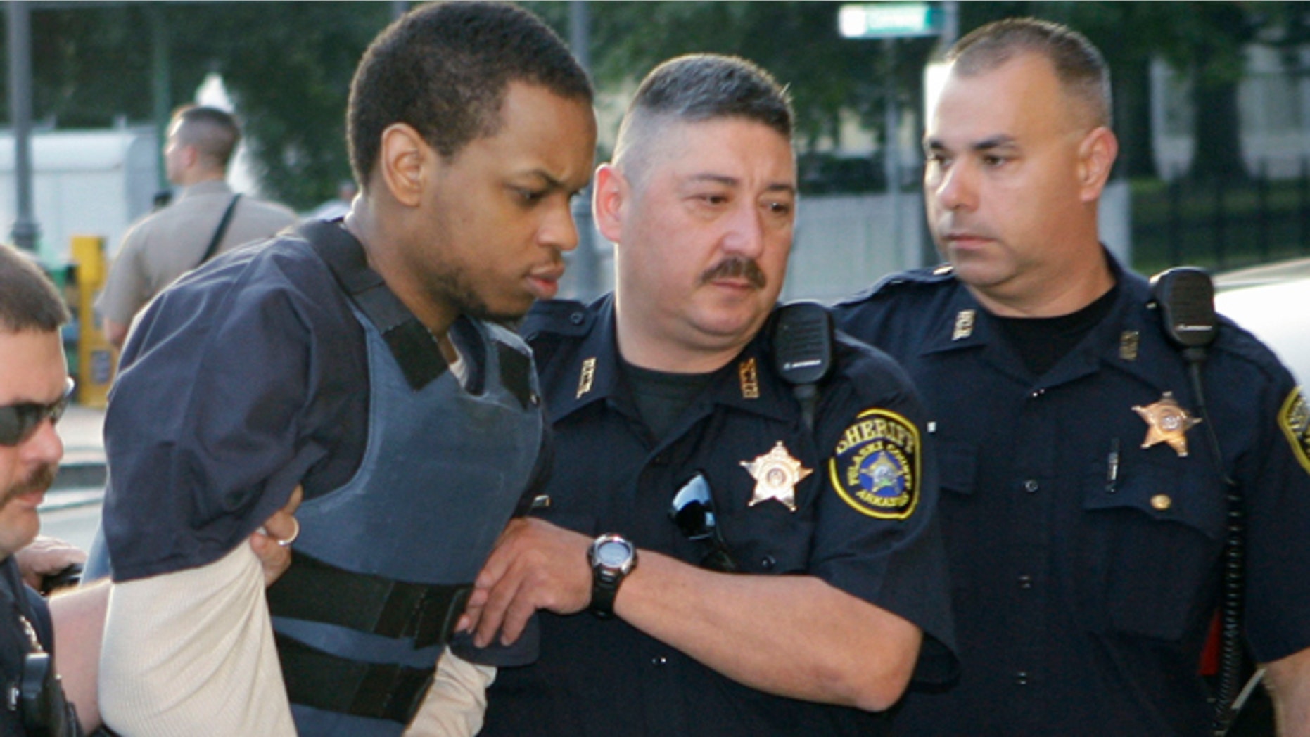 Abdulhakim Muhammad, second from left, is escorted to the Pulaski County Courthouse in Little Rock, Ark.