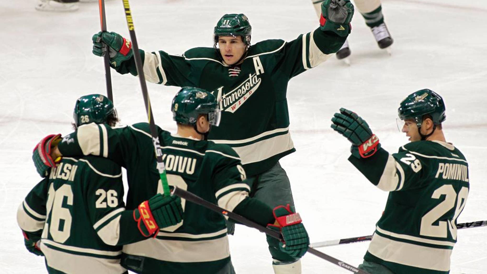 Minnesota Wild center Mikko Koivu (9) of Finland, is congratulated by teammates Matt Moulson (26), Zach Parise (11), and Jason Pominville (29) after scoring a power play goal during the first period of an NHL hockey game, Saturday, March 22, 2014, in St. Paul, Minn. (AP Photo/Paul Battaglia)