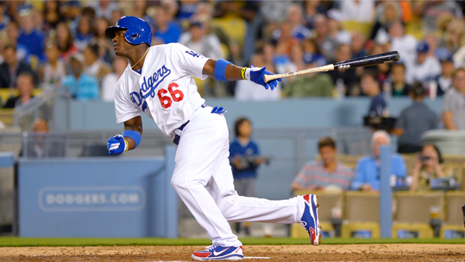 Los Angeles Dodgers Yasiel Puig watches his single in front of Cincinnati Reds catcher Devin Mesoraco during the fourth inning of a baseball game, Thursday, July 25, 2013, in Los Angeles. (AP Photo/Mark J. Terrill)