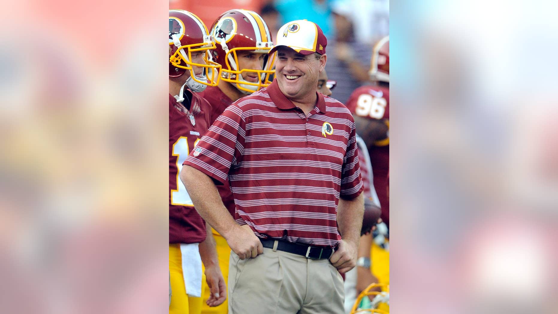 FILE - In this Aug. 7, 2014, file photo, Washington Redskins head coach Jay Gruden stands on the sidelines before an NFL football preseason game against the New England Patriots in Landover, Md. Unlike a year ago, when the Washington Redskins' star quarterback Robert Griffin III and then-head coach Mike Shanahan feuded openly about whether he'd be allowed to test his surgically repaired knee in a preseason game, Griffin and the Redskins wrapped up a drama-free camp under new coach Gruden. (AP Photo/Richard Lipski, File)
