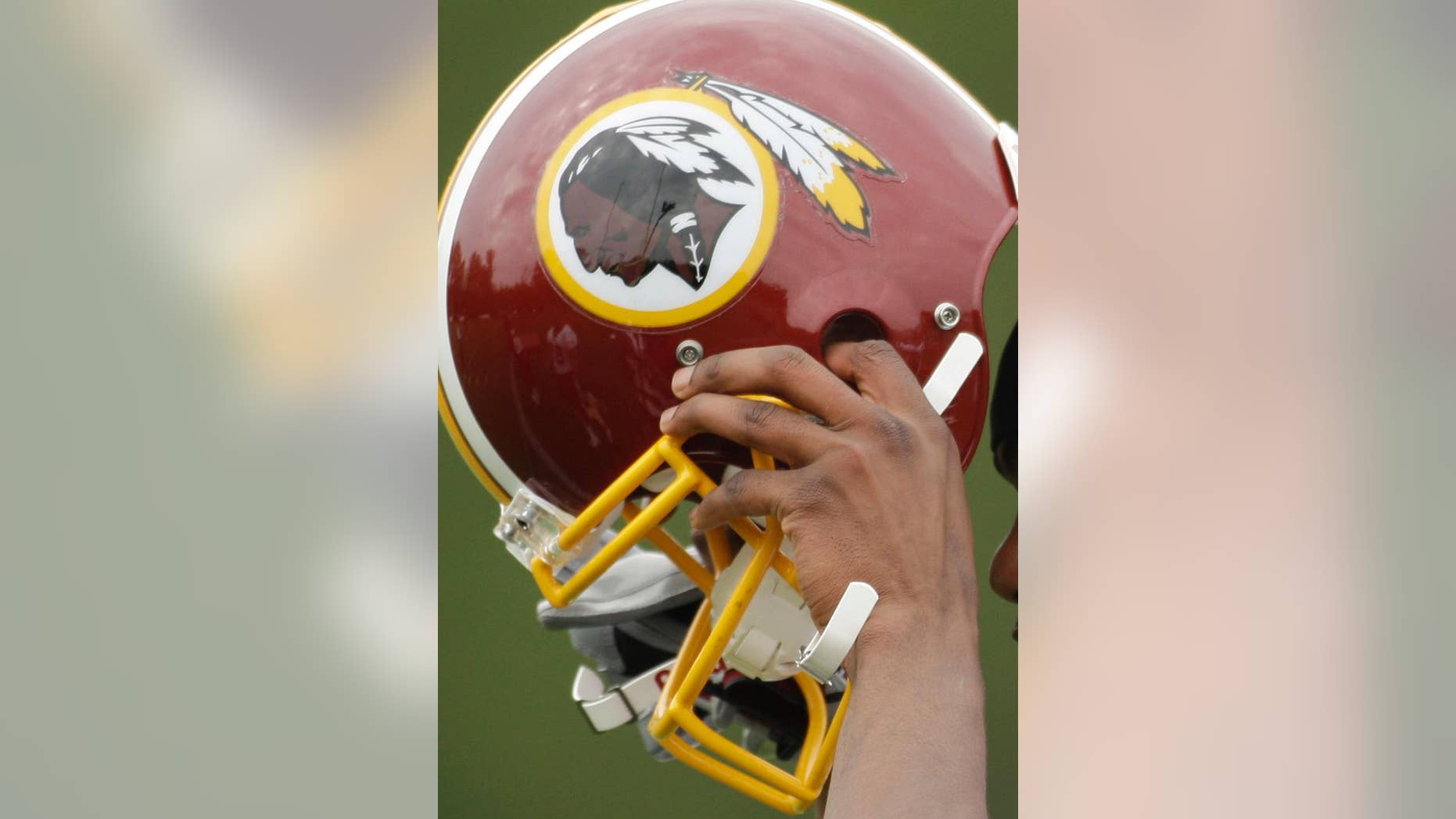 FILE - In this May 1, 2009 file photo, Washington Redskins Marko Mitchell puts his helmet on during their NFL football minicamp practice at their training facility in Ashburn, Va. Half of the U.S. Senate says it's time to change the name of the Washington Redskins. Forty-nine Democratic senators wrote NFL Commissioner Roger Goodell on Thursday, May 22, 2014. They say racism and bigotry do not belong in professional sports. (AP Photo/Alex Brandon, File)