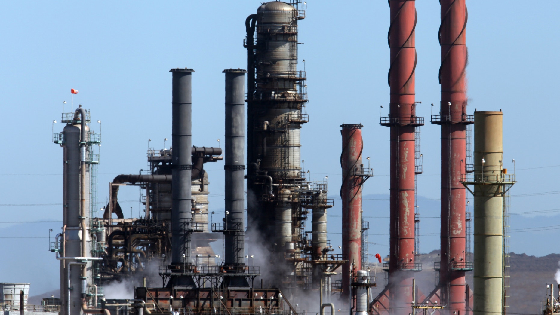 This Aug. 7, 2012 file photo, white smoke rises from the Chevron refinery during a controlled burn, the morning after Monday's toxic fire in Richmond, Calif. Federal investigators probing the cause of a massive Chevron oil refinery fire are focusing on possible corrosion in a decades-old pipe the company inspected late last year but did not replace. Investigators with the U.S. Chemical Safety Board told The Associated Press on Saturday, Aug. 11, 2012, that the November inspection led Chevron to replace an old pipe connected to the one that failed Monday. (AP Photo/The Contra Costa Times, Laura A. Oda)