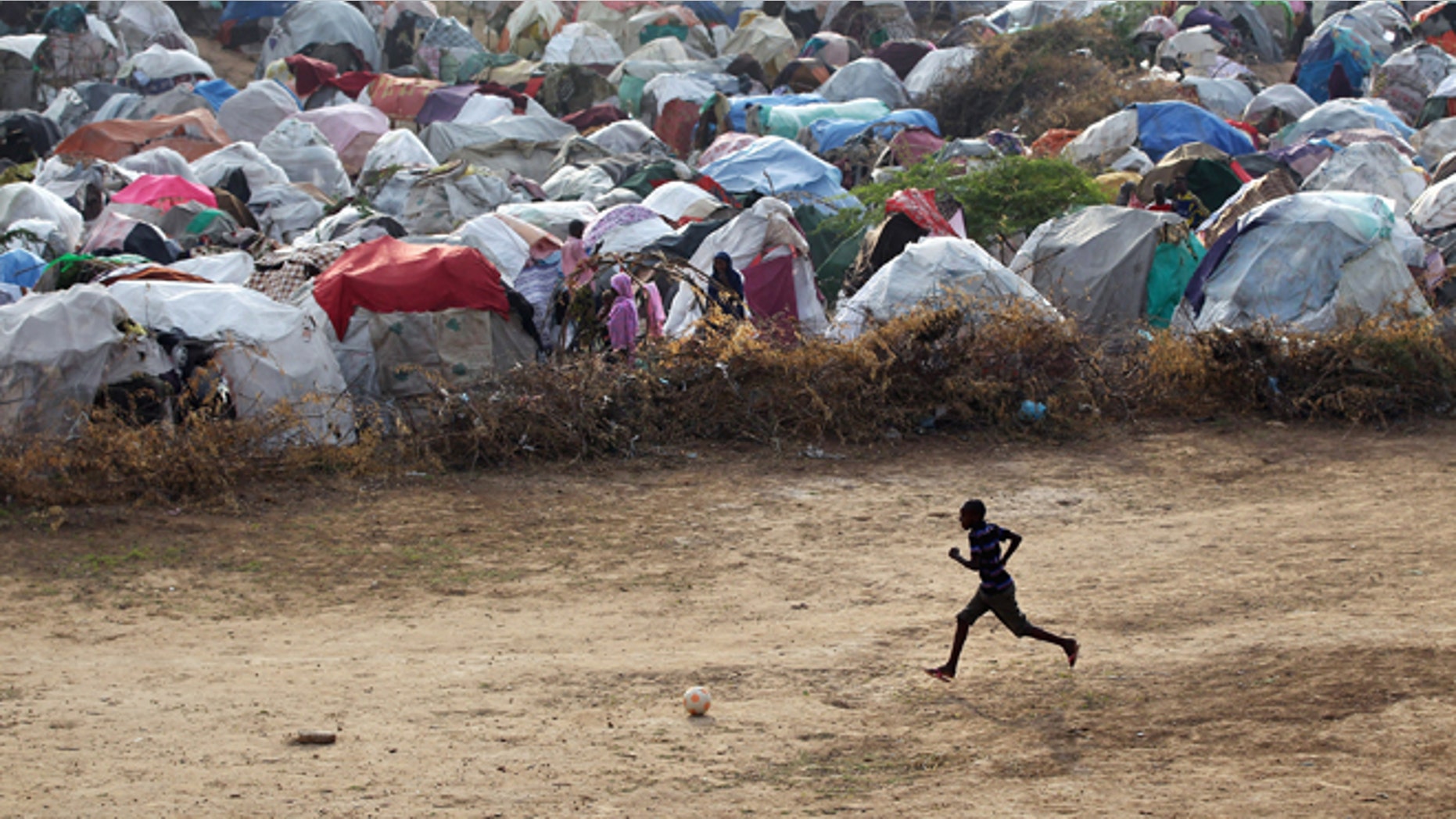 MOGADISHU, SOMALIA - AUGUST 18: A famine refugee plays next to a camp for Somalis displaced by drought and famine on August 18, 2011 in Mogadishu, Somalia. The UN estimates that more than 100,000 people have fled their villages to Mogadishu in the last two months due to the crisis. Some 1.5 million Somalis are estimated displaced nationwide due to drought, famine and war. The UN is investigating reports that thousands of sacks of food aid for famine victims have been stolen and are for sale on the open market. (Photo by John Moore/Getty Images)