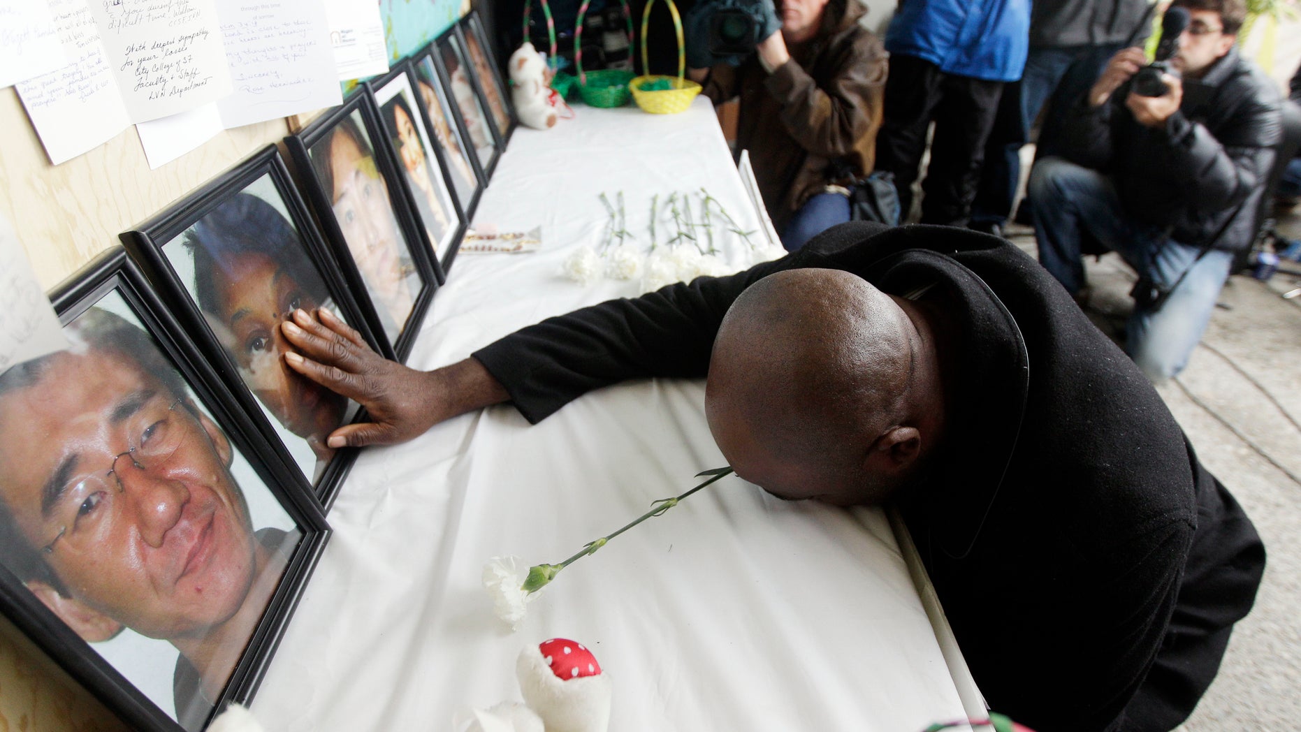 April 10: Efanye Chibuko touches a picture of his wife Doris during a memorial at Oikos University in Oakland, California. Doris Chibuko was among the victims of a shooting rampage at the Oakland school.