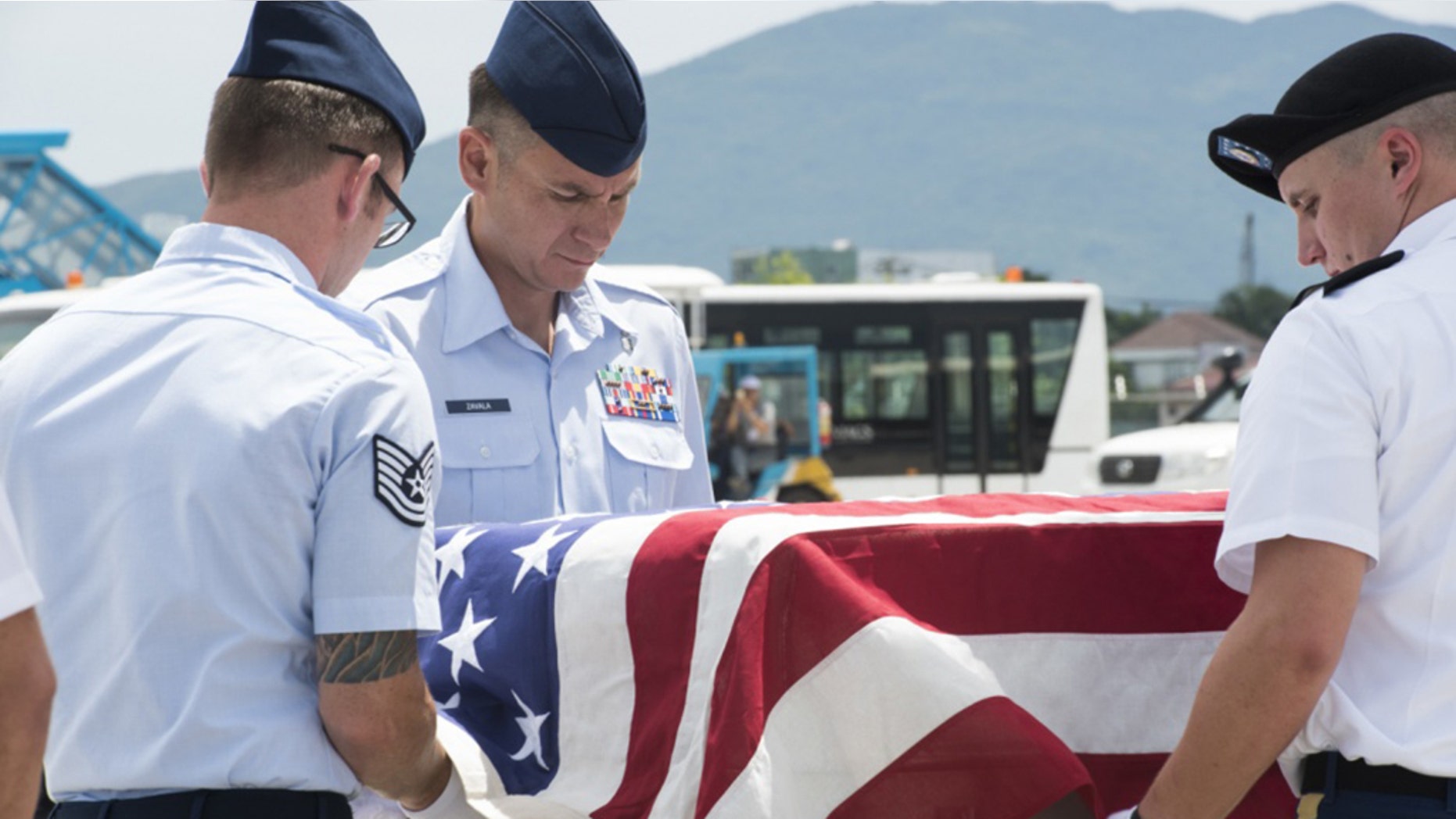 U.S. service members assigned to the Defense POW/MIA Accounting Agency (DPAA), drape a transfer case with the American flag during a repatriation ceremony, Da Nang, Socialist Republic of Vietnam, July 8, 2018.