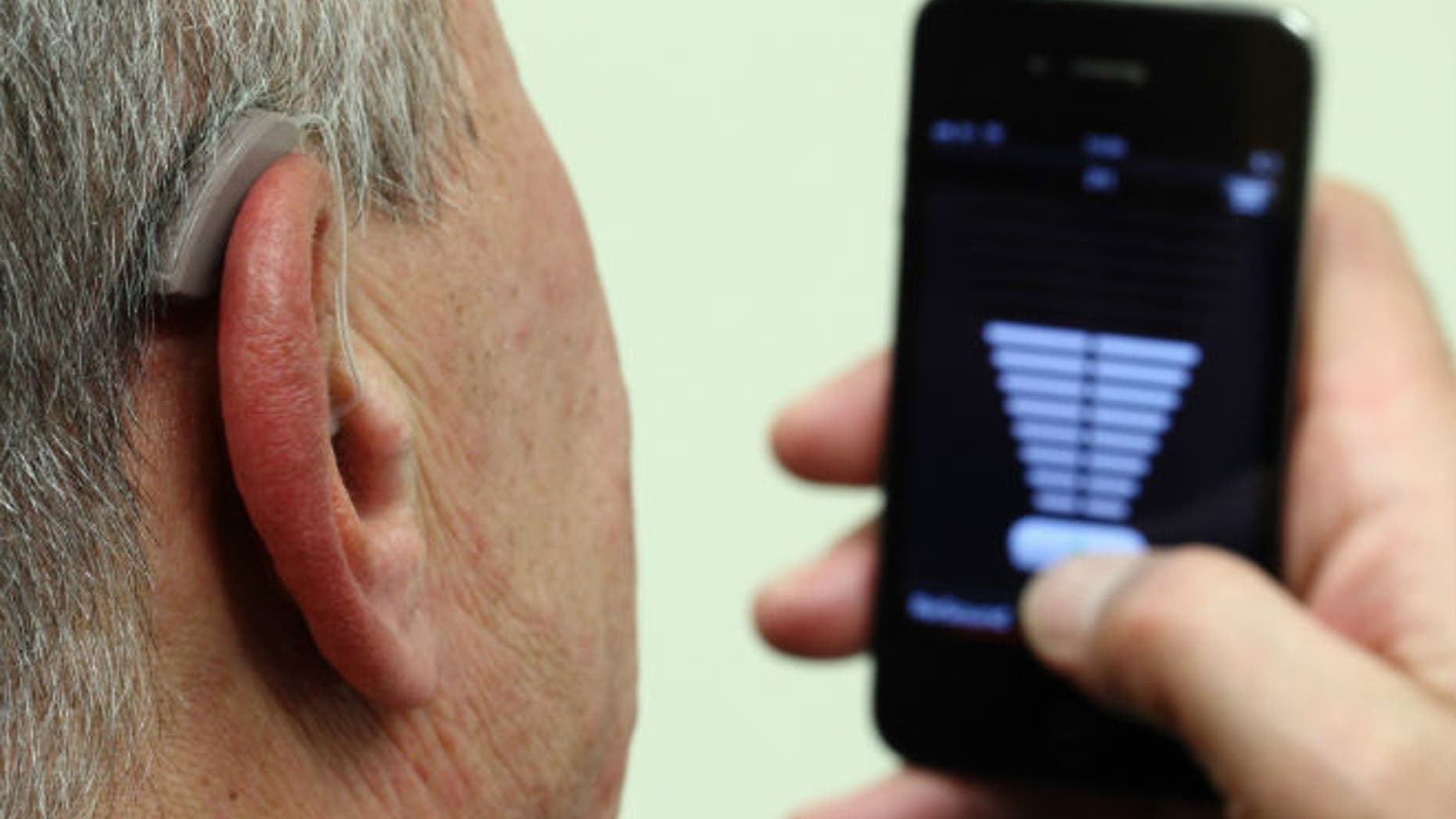 An employee of GN, the world's fourth largest maker of hearing aids, demonstrates the use of ReSound LiNX in Vienna November 22, 2013. (REUTERS/Heinz-Peter Bade)