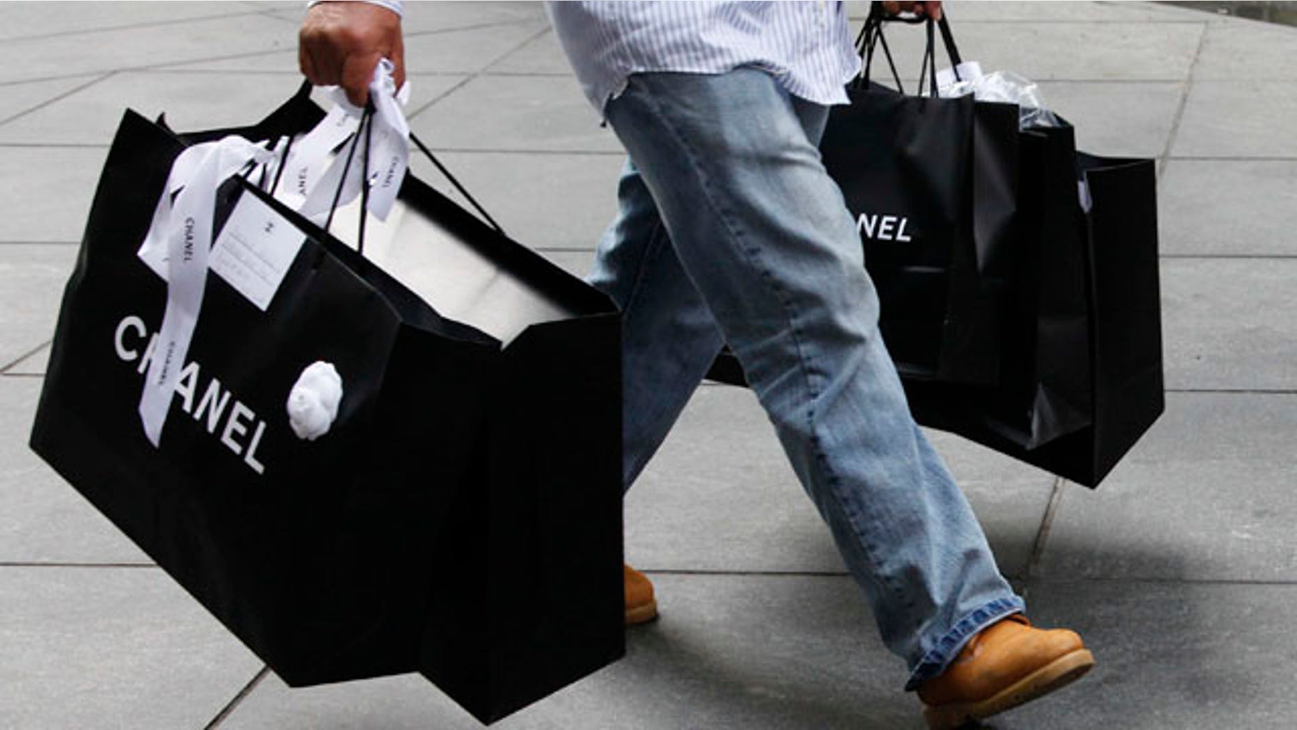 Oct. 25: A man carries Chanel shopping bags in New York. Retail sales increased in October by the largest amount since March, easing worries over the economic recovery.