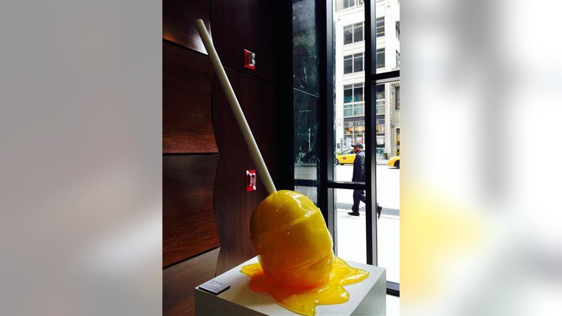 This April 17, 2014 photo shows a sculputure in the form of a giant lollypop by former street artist Desire Obtain Cherish (DOC) on display in the building lobby of 1001 Sixth Avenue in New York.