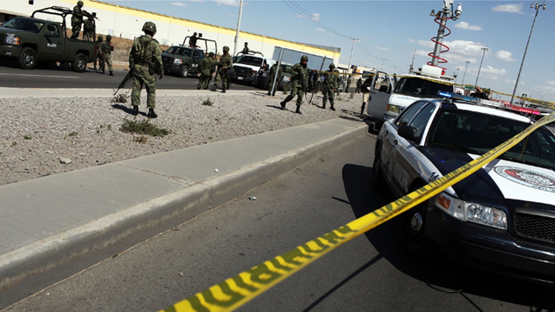 JUAREZ, MEXICO - MARCH 24: Military police keep guard at the site of a murder on March 24, 2010 in Juarez, Mexico. Secretary of State Hillary Rodham Clinton, Defense Secretary Robert Gates, and Homeland Security Secretary Janet Napolitano all visited Mexico yesterday for discussions centered on Mexico's endemic drug-related violence. The border city of Juarez, Mexico has been racked by violent drug-related crime recently and has quickly become one of the most dangerous cities in the world in which to live. As drug cartels have been fighting over ever-lucrative drug corridors along the United States border, the murder rate in Juarez has risen to 173 slayings for every 100,000 residents. President Felipe Calderon's strategy of sending 7000 troops to Juarez has not mitigated the situation. With a population of 1.3 million, 2,600 people died in drug-related violence last year and 500 so far this year, including two Americans recently who worked for the U.S. Consulate and were killed as they returned from a child's party. (Photo by Spencer Platt/Getty Images)