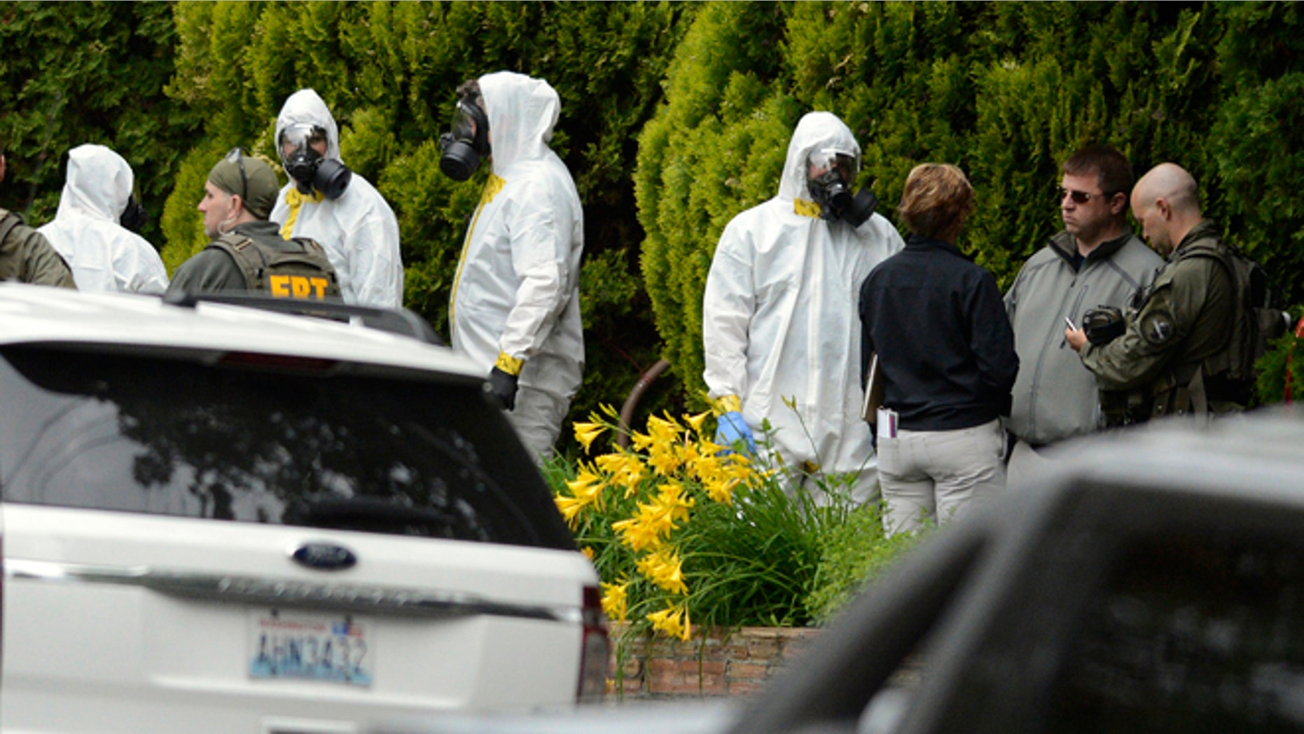 May 18, 2013: During the execution of a search warrant, members of the Joint Federal Haz-Mat Team, FBI, and local law enforcement gather in front of the Osmun Apartments near the intersection of First Avenue and Oak Street in Browne's Addition on Saturday in Spokane, Wash. The search warrant is in connection with ricin-laced letters intercepted at a Post Office facility in Spokane earlier in the week.