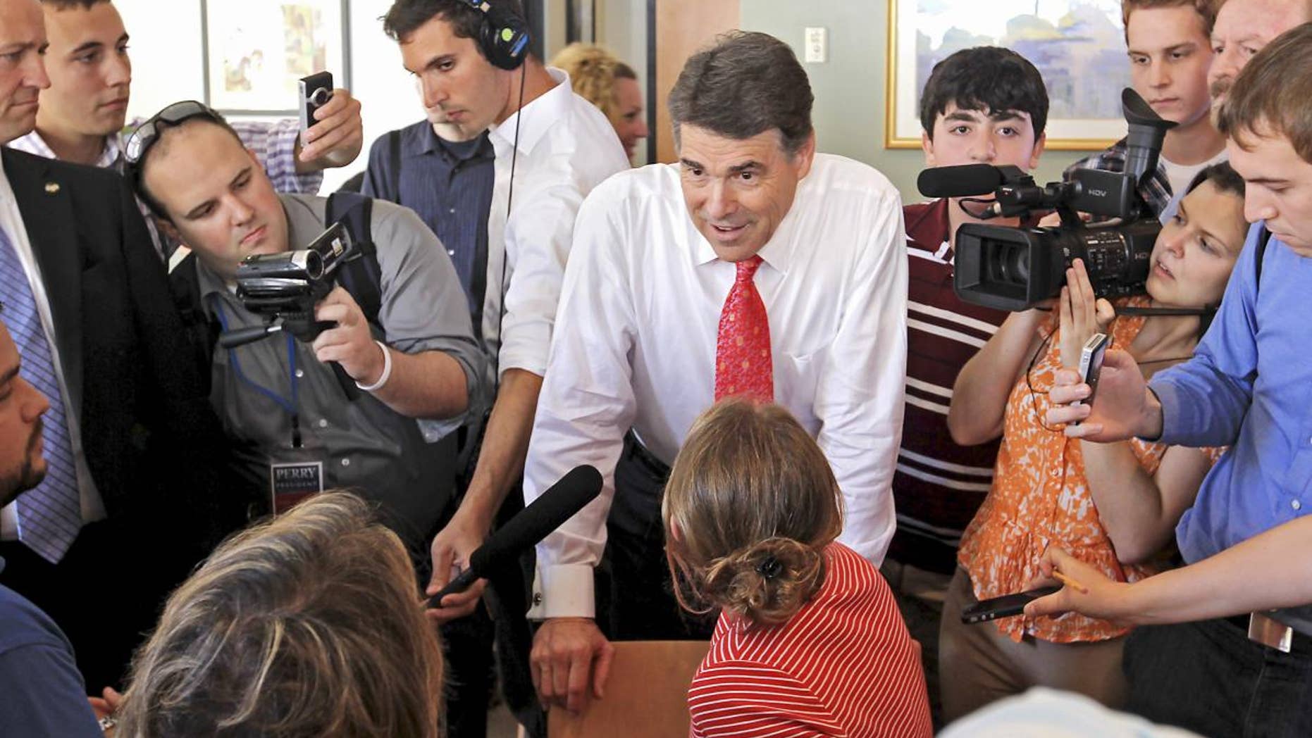 Republican presidential candidate, Texas Gov. Rick Perry talks with locals in a cafe during a visit to downtown Portsmouth, N.H., Thursday, Aug. 18, 2011. (AP Photo/Cheryl Senter)