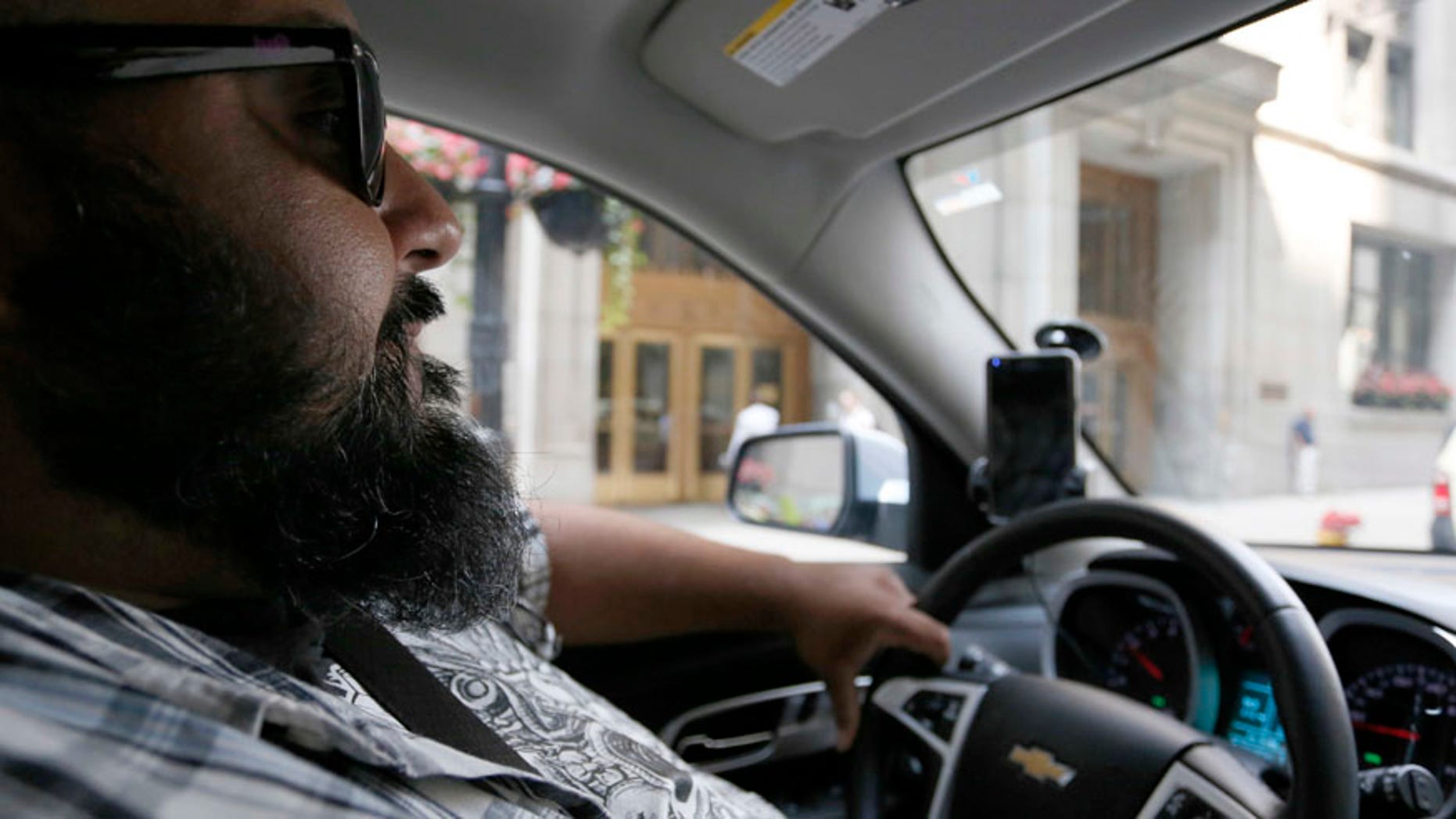 In this July 19, 2016 photo, Carlos Correa drives in Chicago. Correa is currently in Lyft's;s Express Drive rental program, a partnership with GM which allows a weekly rental, available for up to eight weeks. (AP Photo/Tae-Gyun Kim)