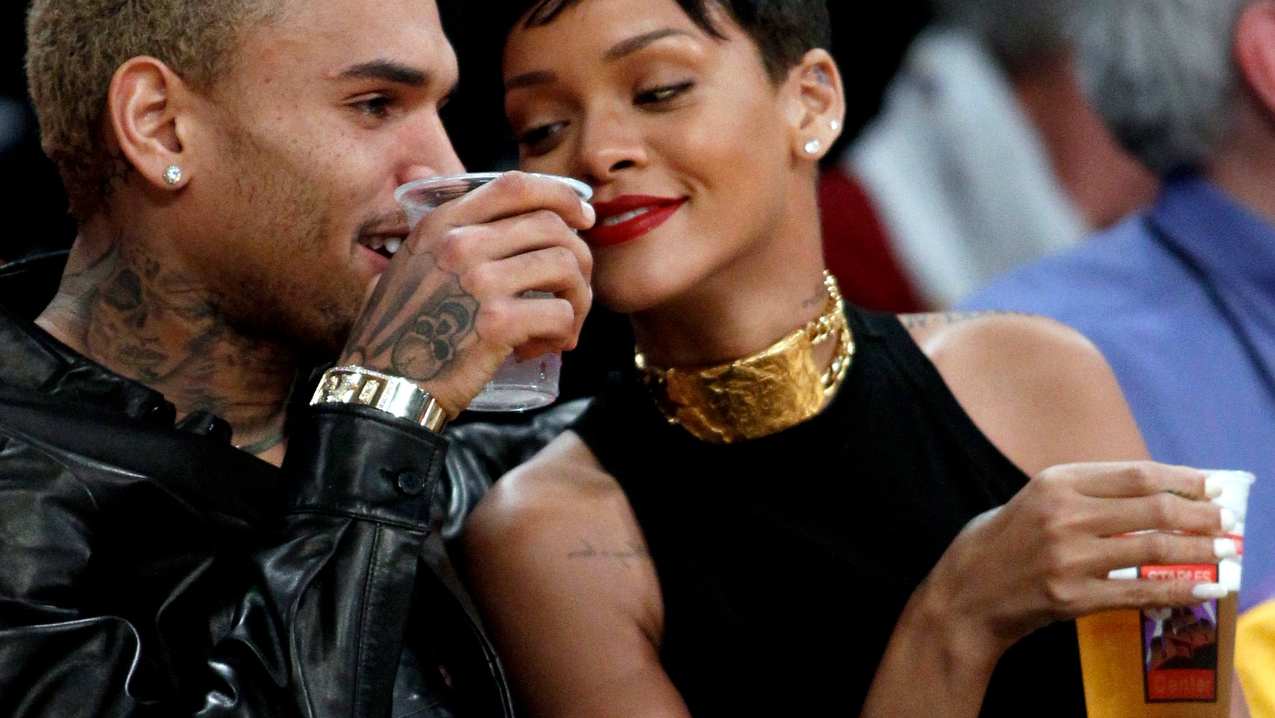 Chris Brown, left, and Rihanna attend an NBA basketball on Dec. 25, 2012.