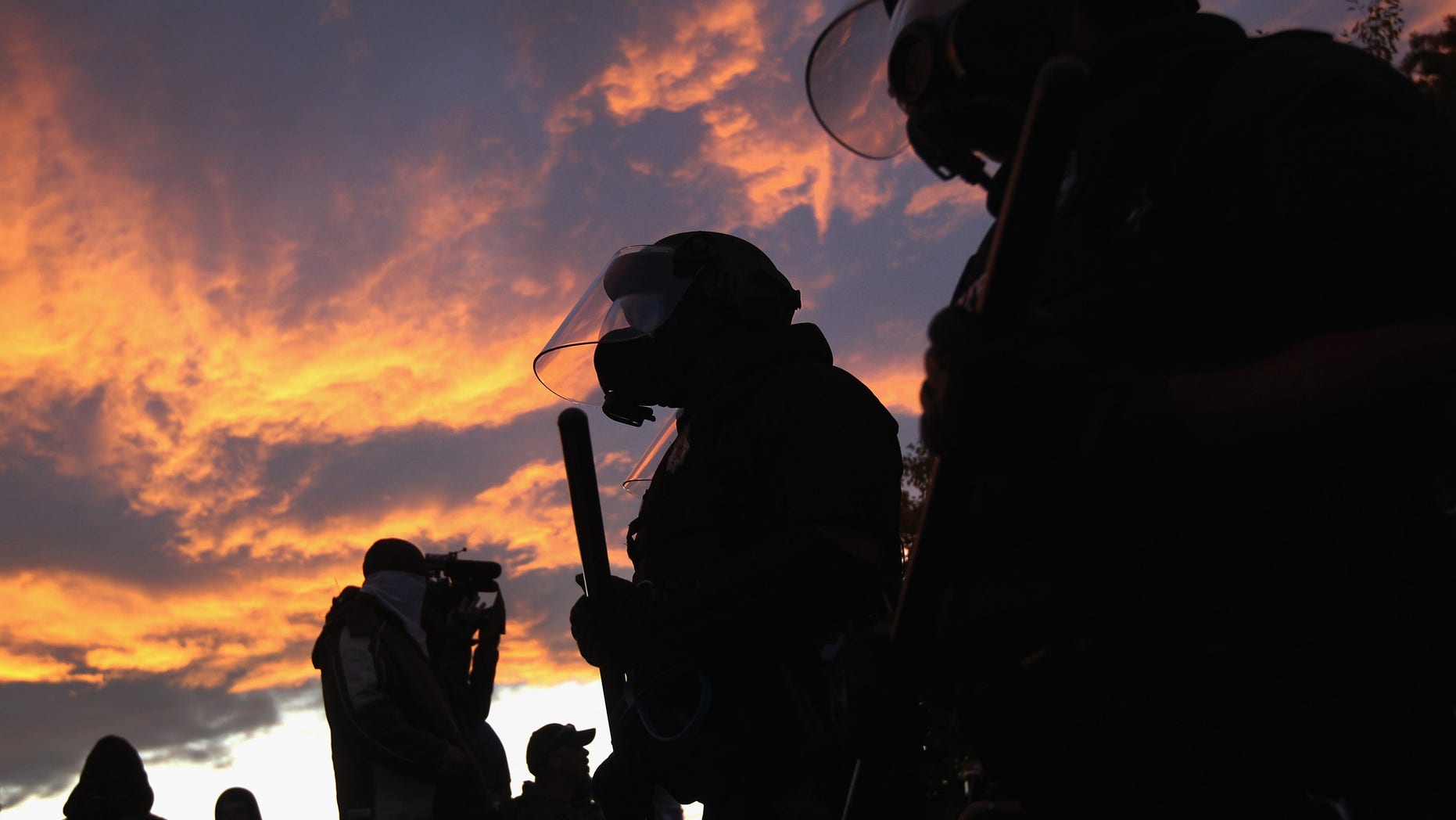 DENVER, CO - OCTOBER 29: Riot police face off with demonstrators at the "Occupy Denver" camp on October 29, 2011 in Denver, Colorado. Following a march by protesters, police moved in on their encampment to tear down recently erected tents. They arrested numerous protesters, pepper-sprayed others and others reportedly fired rubber bullets at the crowd during the confrontation. (Photo by John Moore/Getty Images)