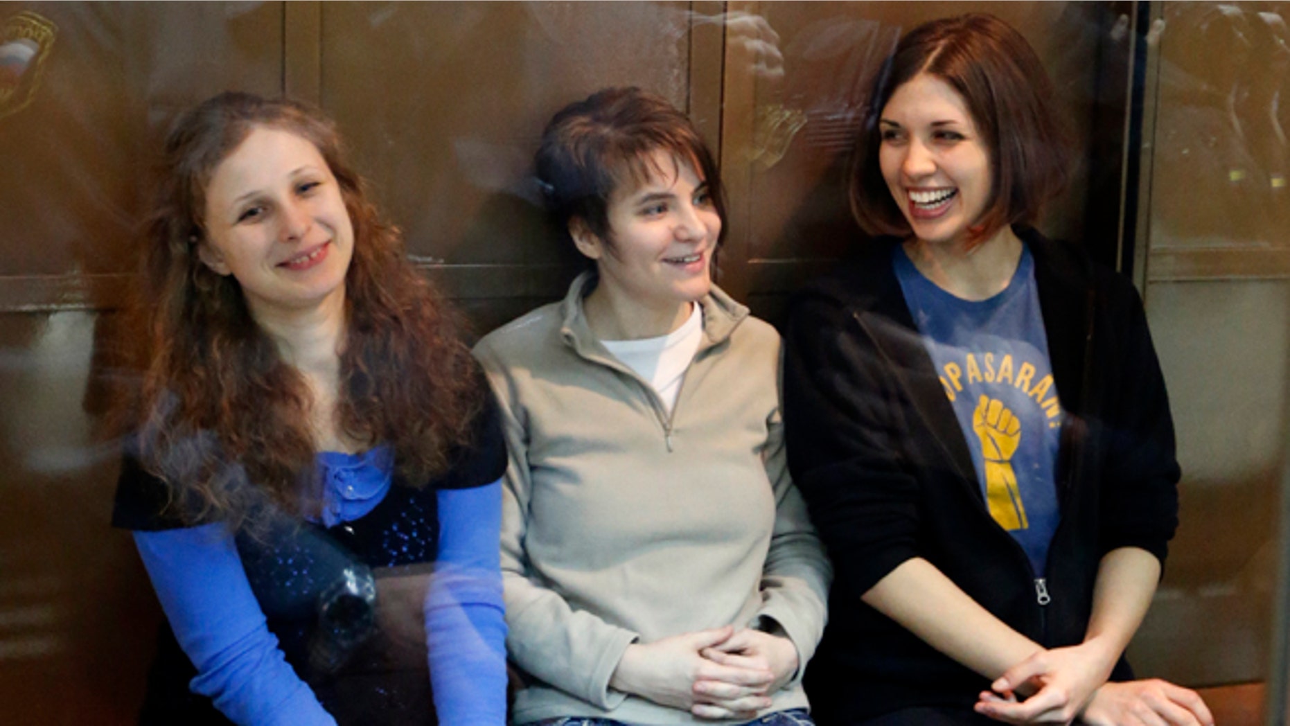 In this Oct. 1, 2012 file photo, feminist punk group Pussy Riot members, from left, Maria Alekhina, Yekaterina Samutsevich and Nadezhda Tolokonnikova sit in a glass cage at a court room in Moscow, Russia. Alekhina went on hunger strike May 22, 2013, in protest at not being allowed to attend her own parole hearing in Perm province.