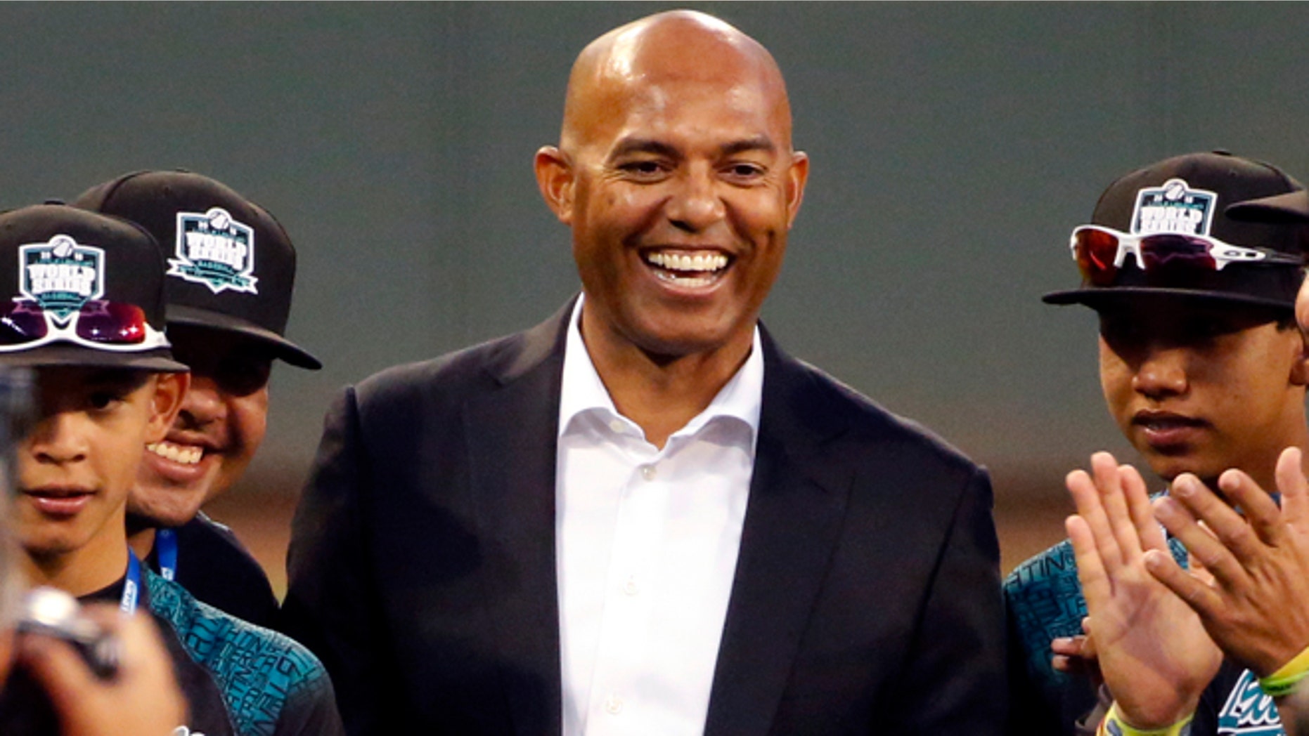 Former New York Yankee closer Mariano Rivera, center, poses for a picture with the Little League team from Venezuela before accepting his award for being named to the Little League Hall of Fame, before a U.S. elimination baseball game between Bonita, Calif., and Bowling Green, Ky. at the Little League World Series in South Williamsport, Pa., Tuesday, Aug. 25, 2015. (AP Photo/Gene J. Puskar)
