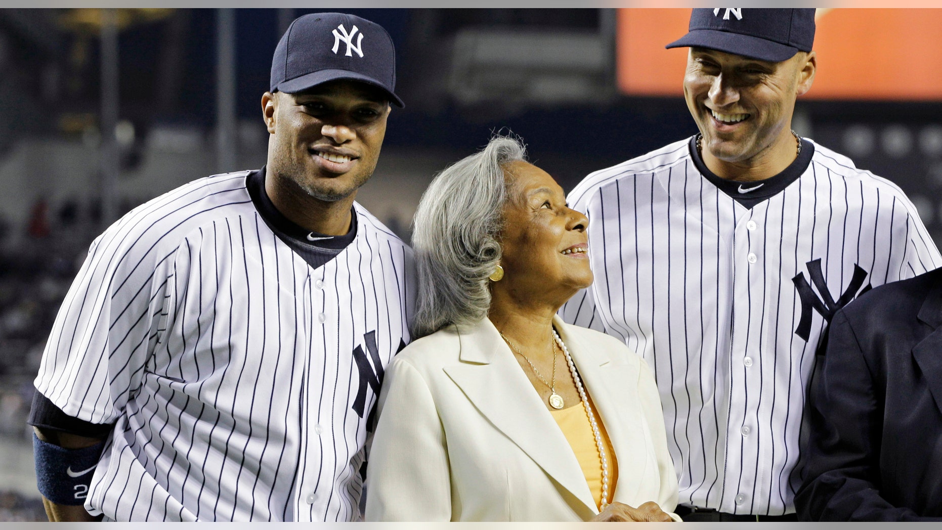 New York Yankees second baseman Robinson Cano, left, and shortstop Derek Jeter join Rachel Robinon, widow of Jackie Robinson, on the field prior to the Yankees' baseball game against the Los Angeles Angels on Jackie Robinson Day at Yankee Stadium in New York, Sunday, April 15, 2012. (AP Photo/Kathy Willens)