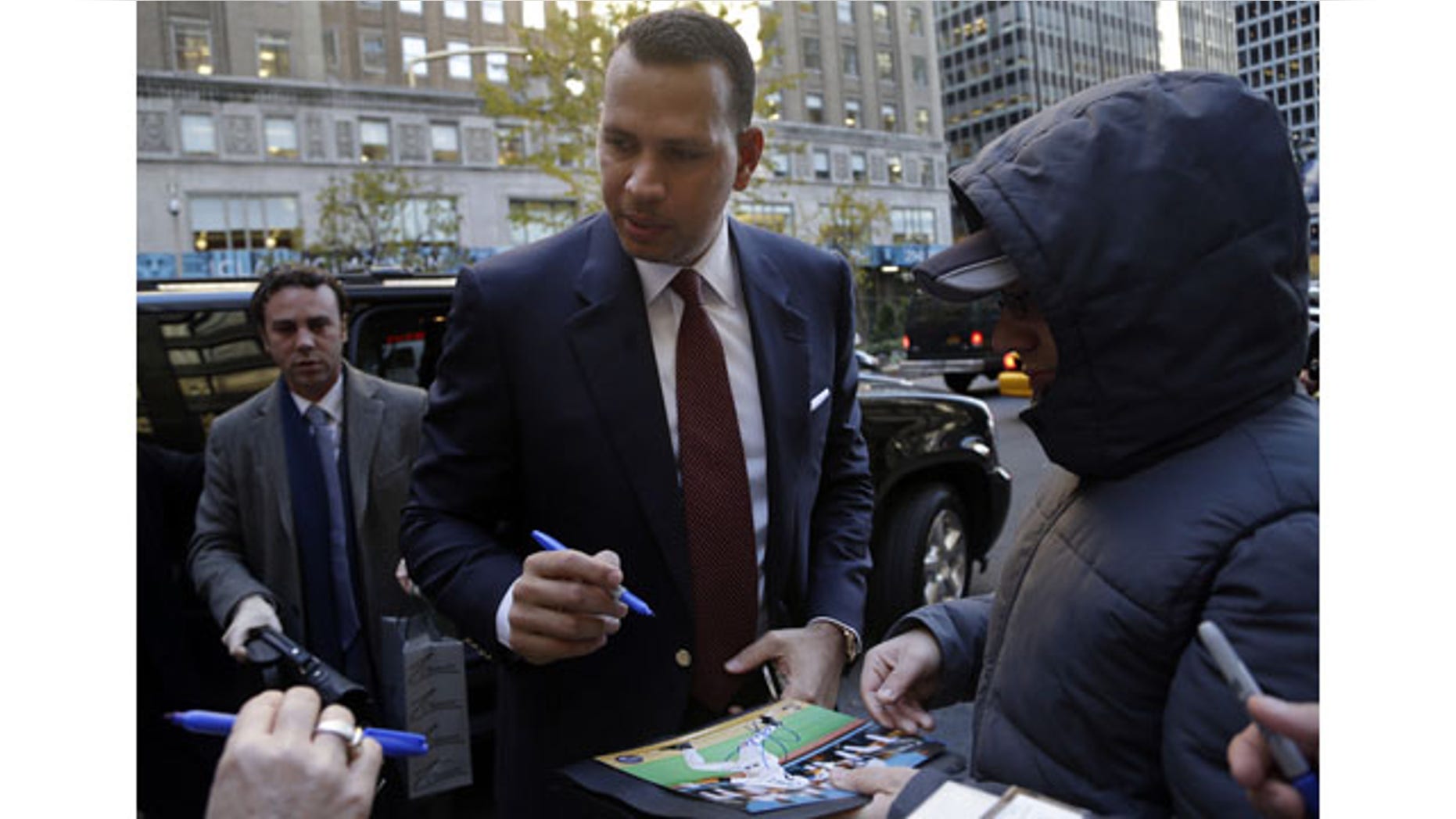 November 19, 2013: Alex Rodriguez signs autographs as he arrives at Major League Baseball headquarters in New York. Rodriguez's grievance hearing to overturn his 211-game suspension resumed Monday with the first of what could be 10 straight days of sessions. (AP Photo/Seth Wenig)