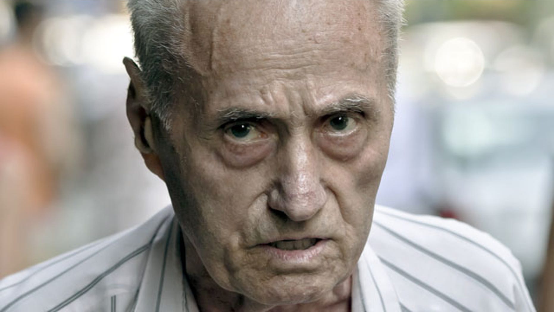 Retired Lt. Col. Alexandru Visinescu, 87, looks at journalists outside his home in Bucharest. Romanian prosecutors on Tuesday Sept. 3, 2013 charged the commander of a Communist-era prison with genocide, the first Romanian to face the charge since 1989. Visinescu appeared before prosecutors to be presented with the charges. Between 1956 and 1963, he ran the Ramnicu Sarat prison where the pre-Communist elite and intellectuals were incarcerated. (AP Photo/Vadim Ghirda. File)
