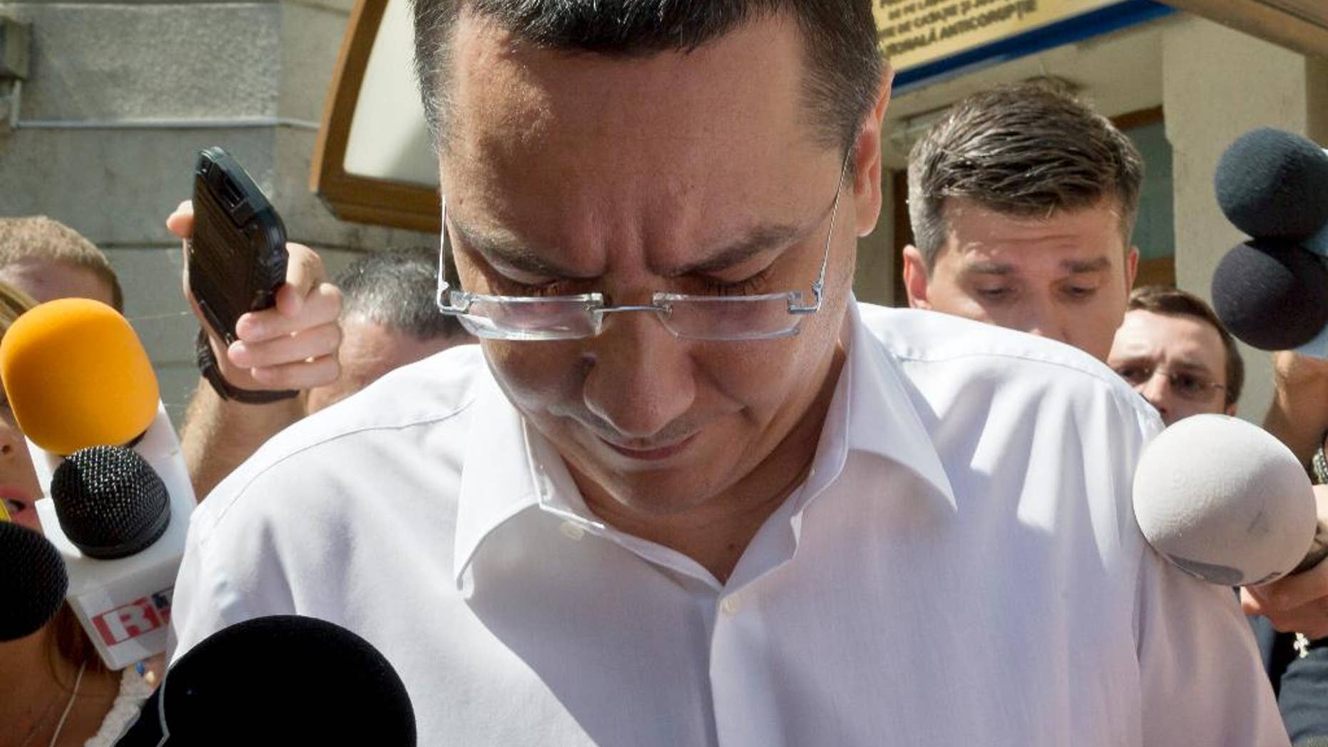 FILE - In this Monday, July 13, 2015 file photo, Romanian Premier Victor Ponta is surrounded by media as he exits the national anti-corruption prosecutors office where he was questioned in Bucharest, Romania. Romanian prosecutors on Thursday Sept. 17, 2015 formally indicted Prime Minister Victor Ponta on corruption charges, including tax evasion and money-laundering, and said he will be tried by the country’s top court. (AP Photo/Vadim Ghirda, File)